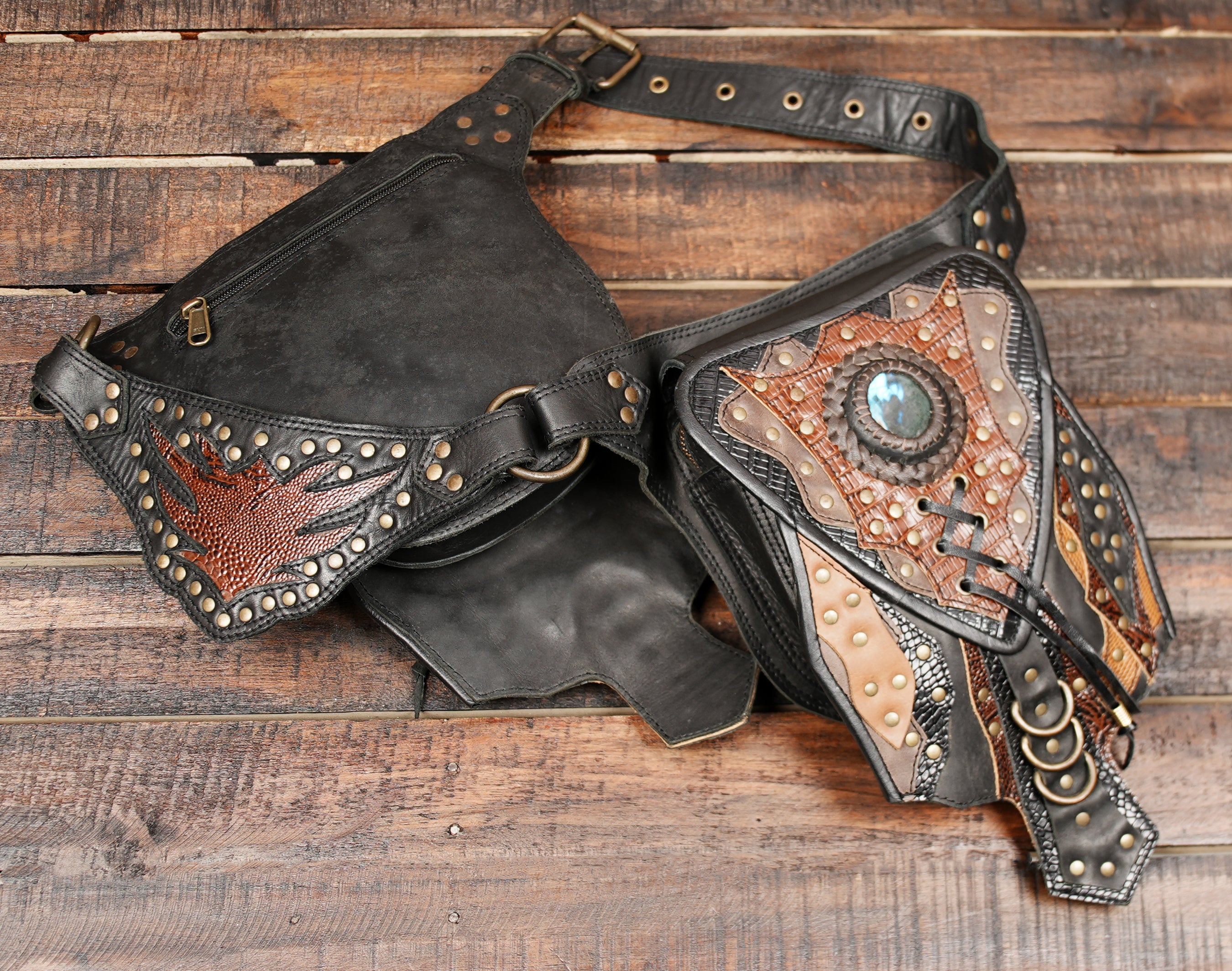 Made from premium black and brown leather, it features two detailed pouches with gemstone accents, studs, and tribal-inspired stitching.