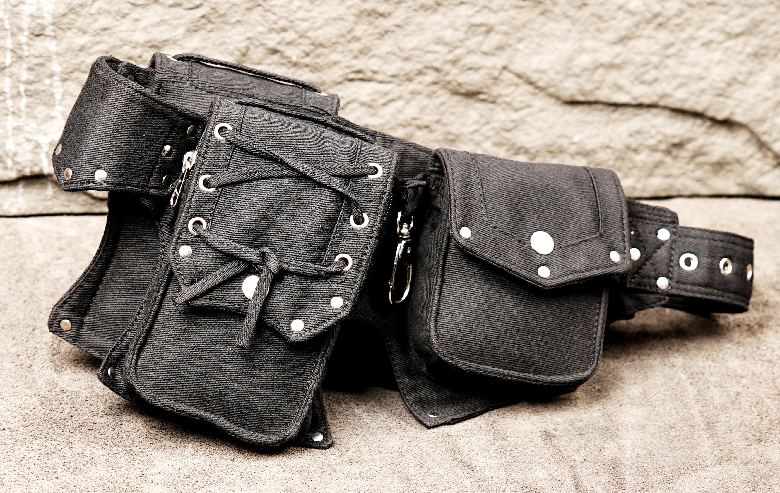 Gothic-inspired black canvas hip belt fanny pack with secure metal studding and lace-up details.