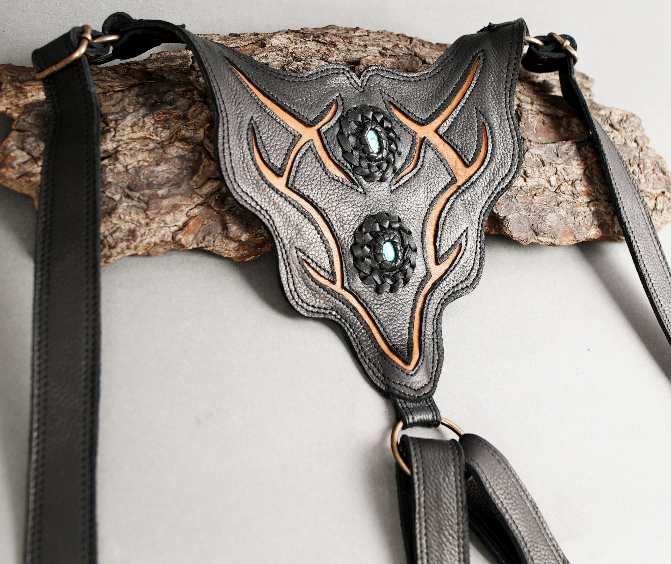 Adjustable shoulder leather holster with decorative stitching.