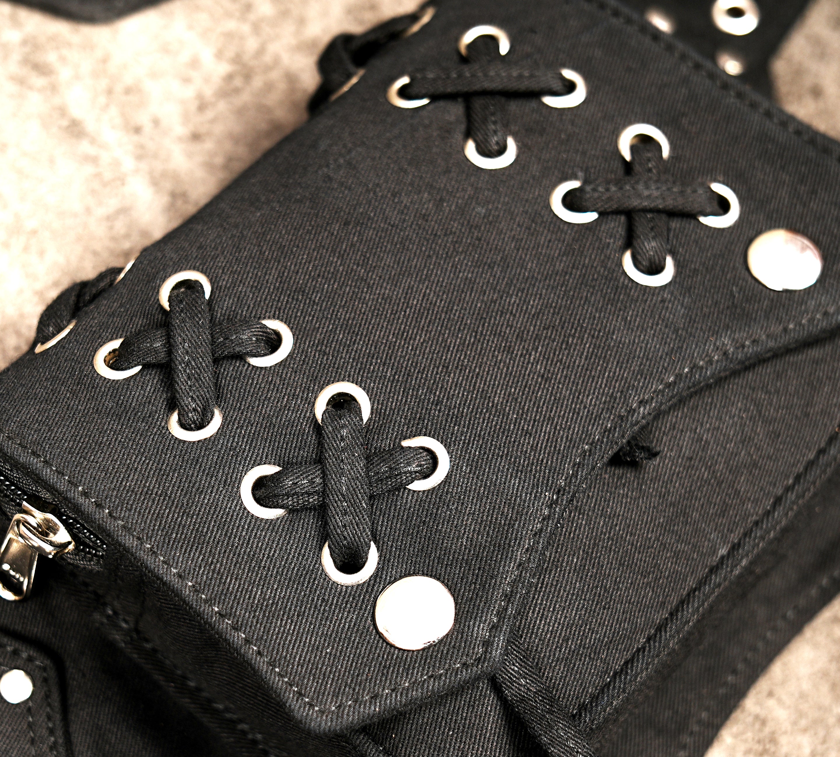 Unisex black hip belt bag featuring secure snap-button pockets and silver buckle.