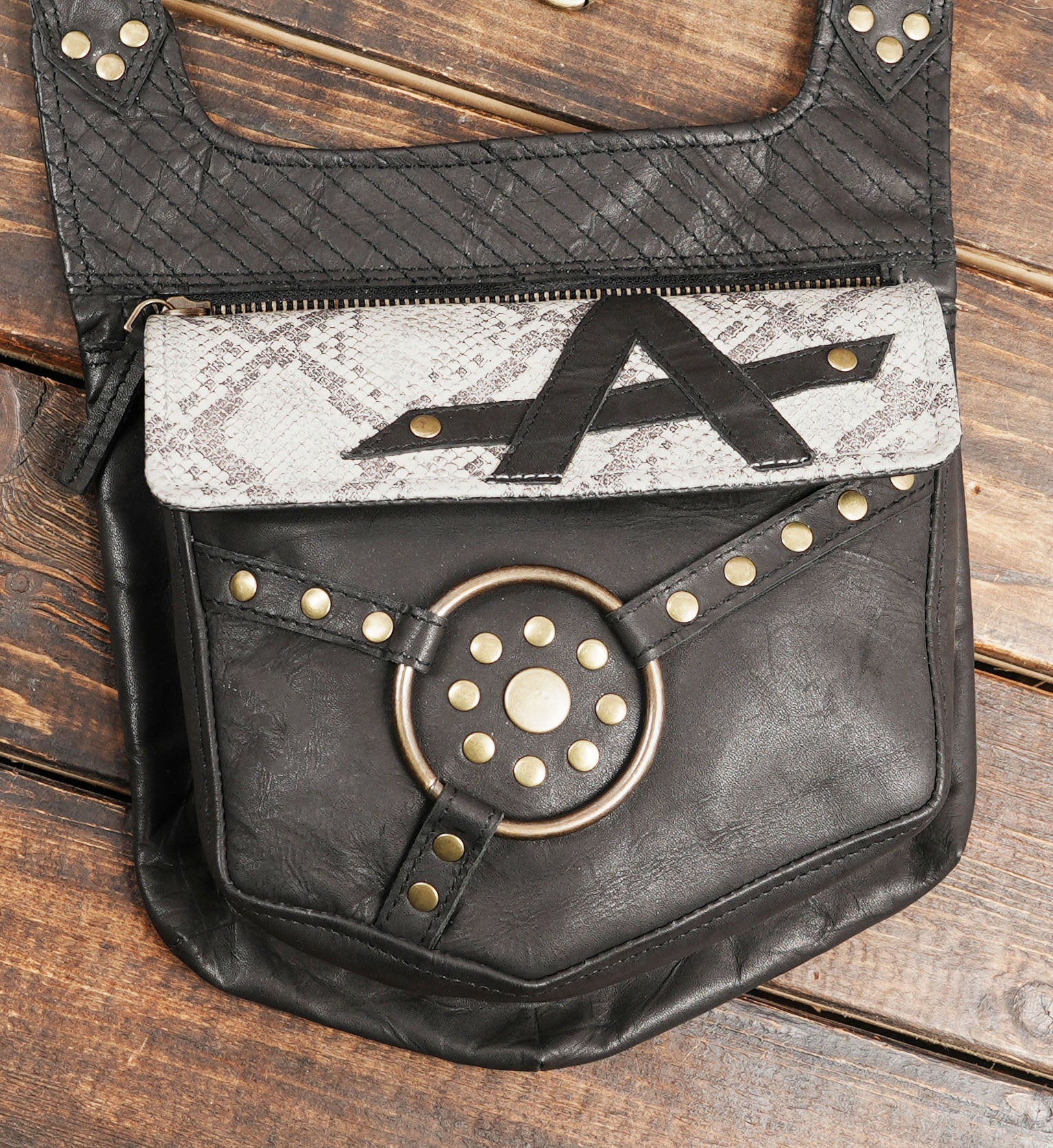 Adjustable leather harness belt featuring snakeskin print and metal rivets.