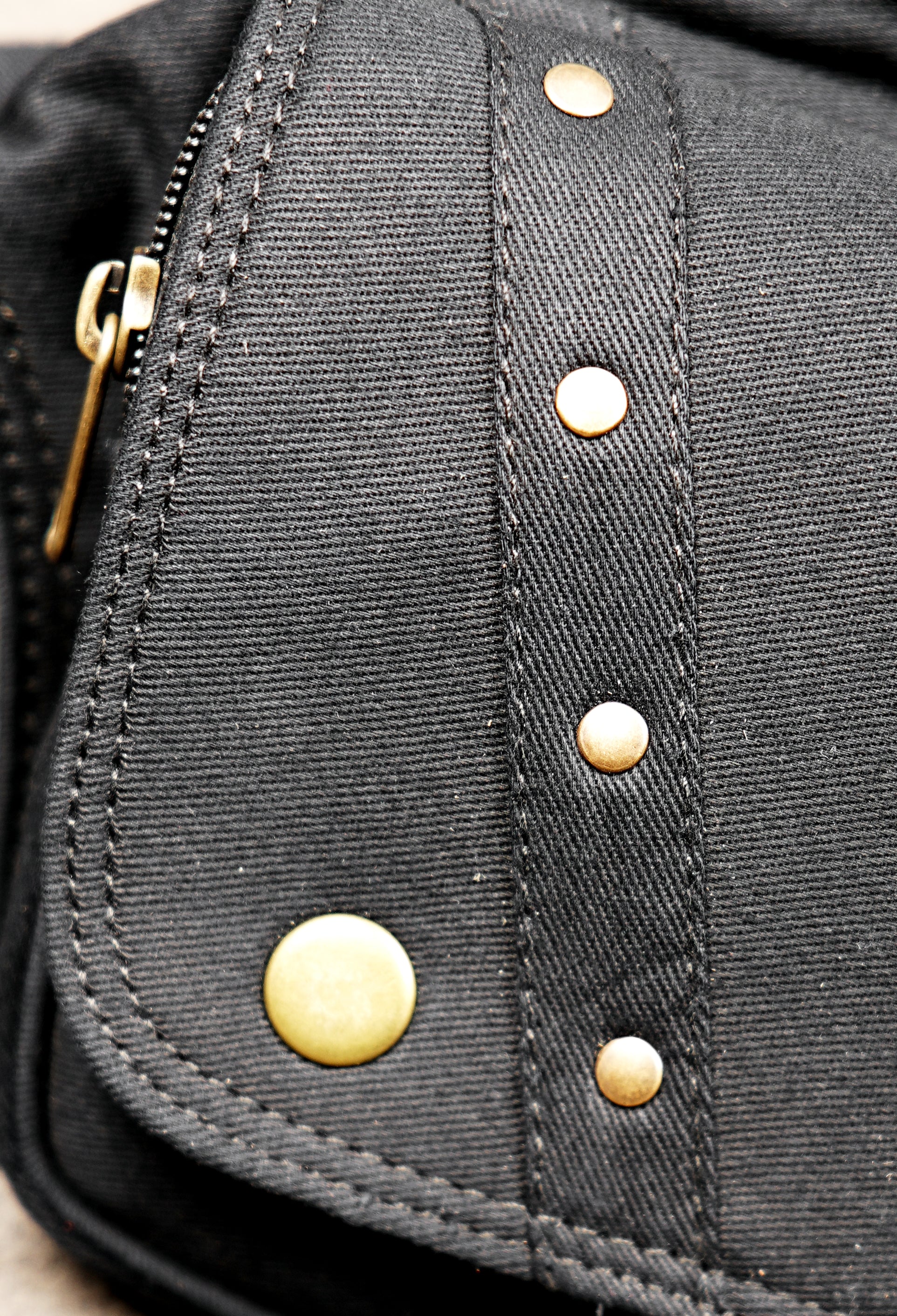 Black utility waist bag with decorative eyelets and secure pockets