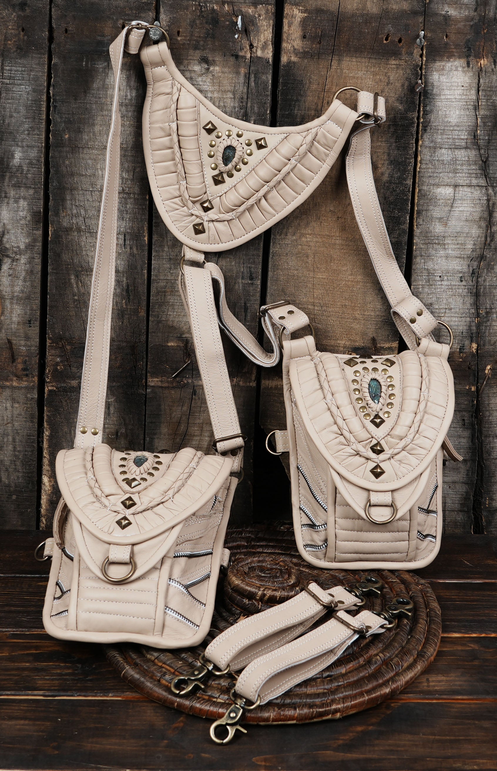 “Cream leather shoulder holster with decorative stitching and brass studs”