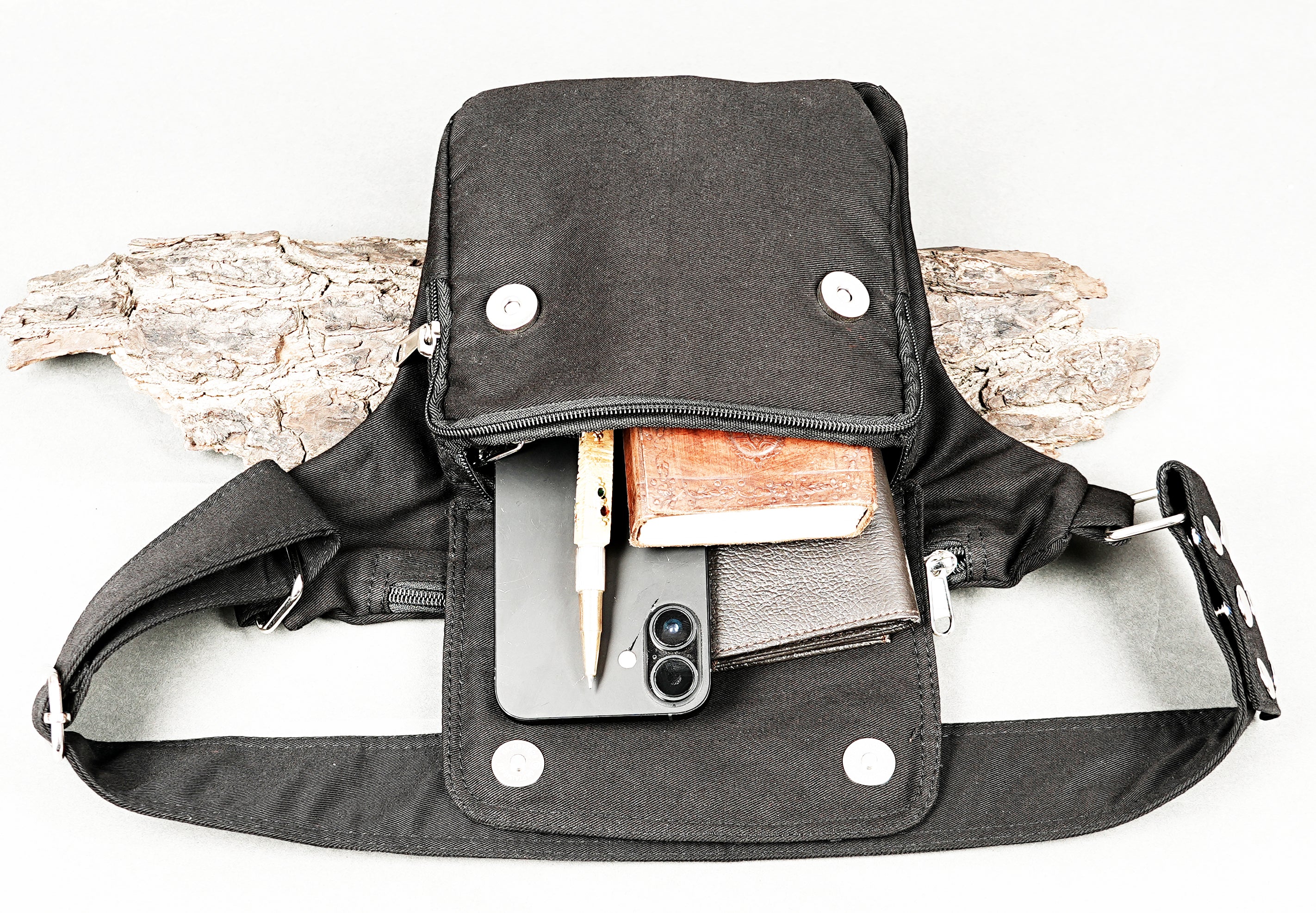 Minimalist black hip bag attached to a sturdy waist strap with eyelet details.