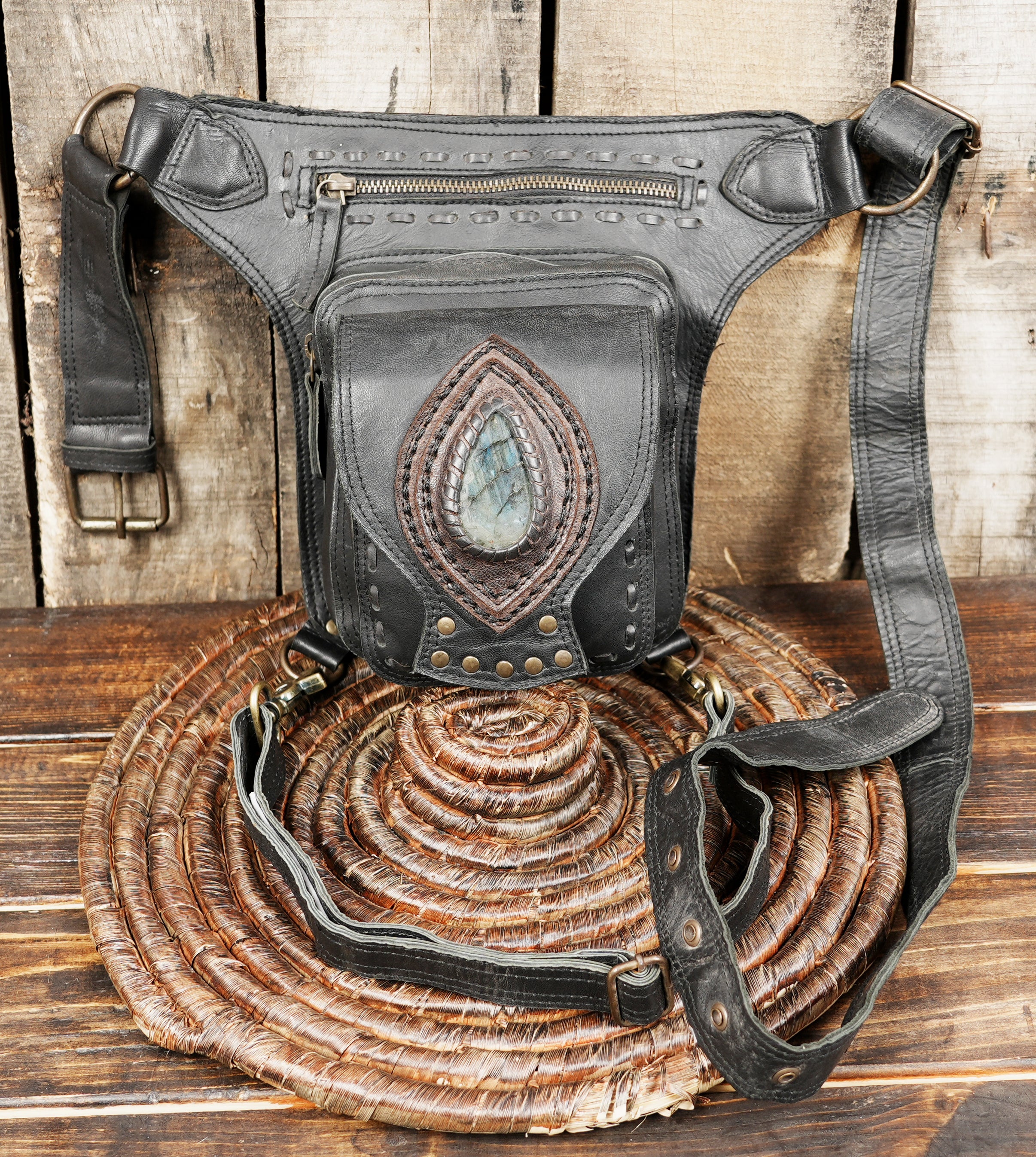 Black leather waist bag with multiple pockets and gemstone design
