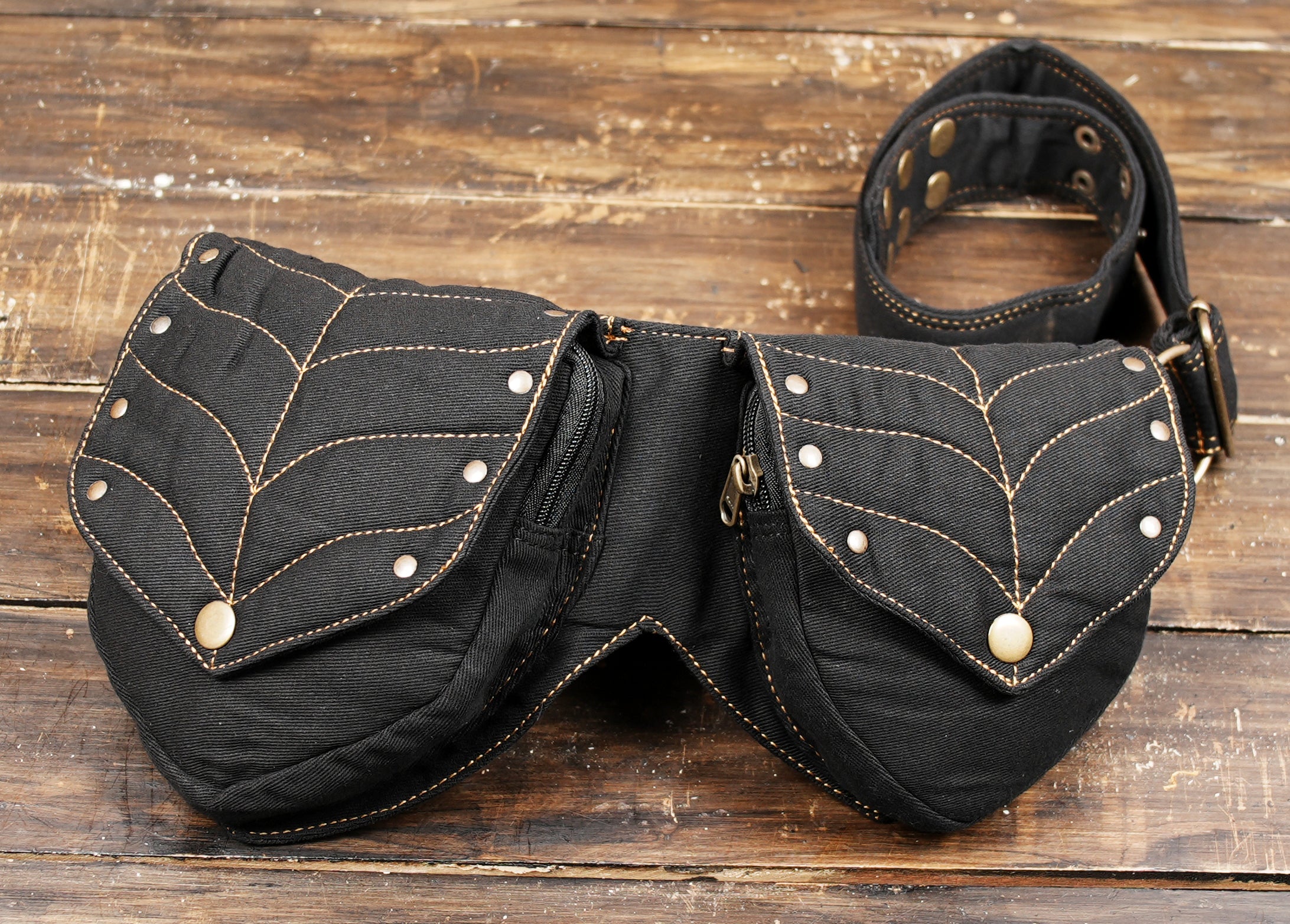 Durable black cotton hip pack, featuring two secure zippered pockets with a stylish leaf pattern.