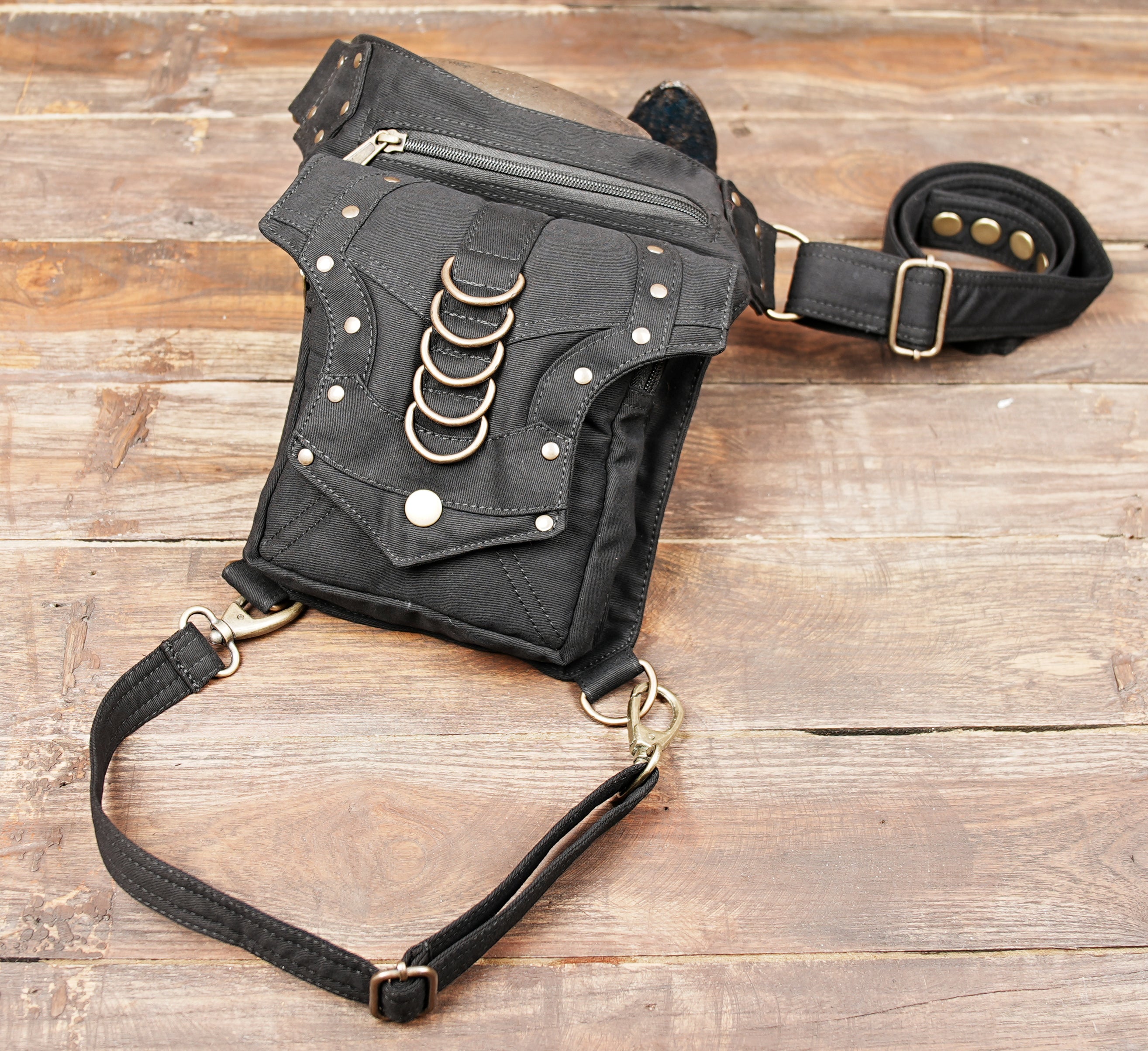 Unisex cotton canvas hip and thigh bag with multi-pocket zippered storage for concerts and travel.