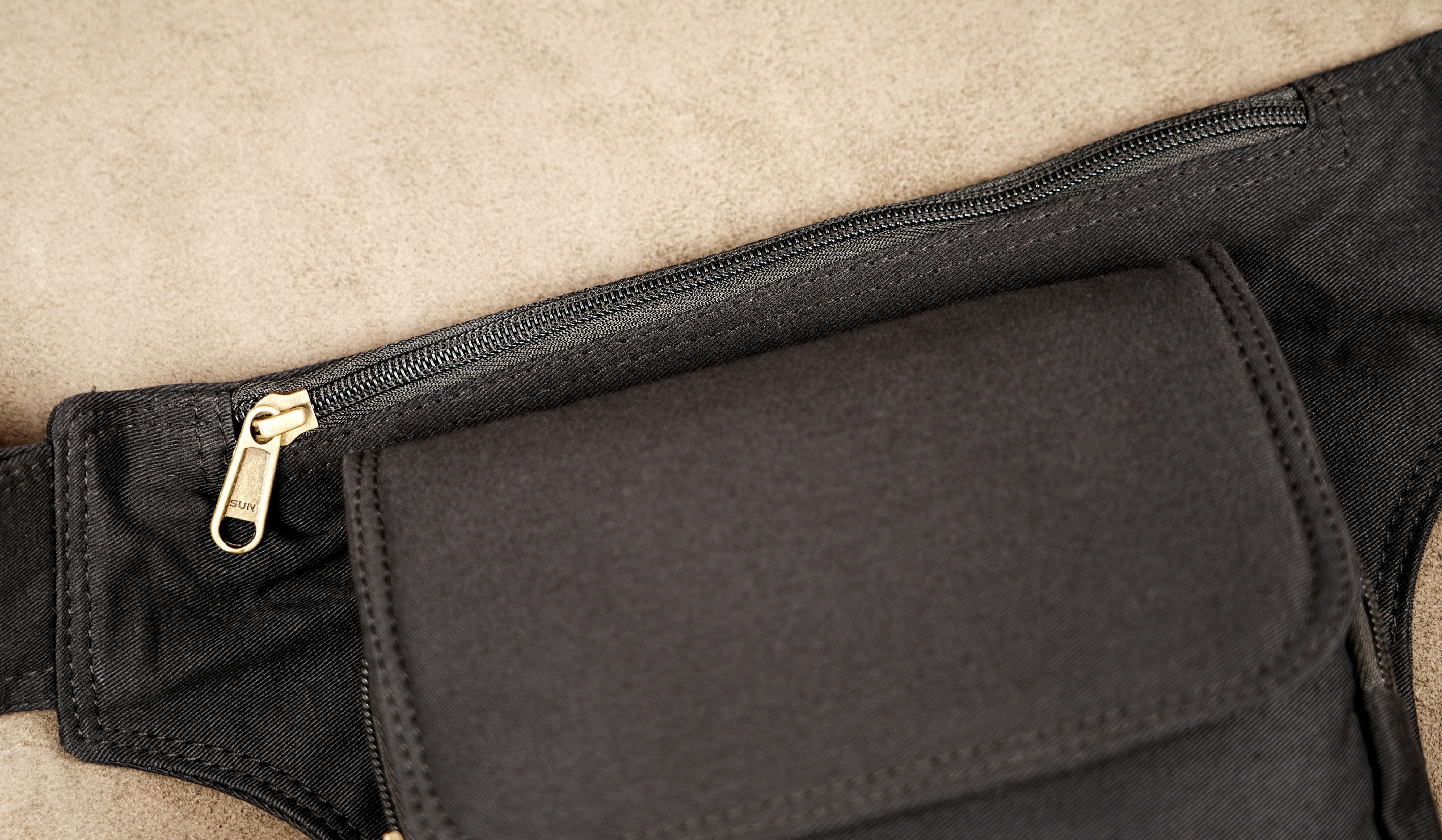Black cotton fanny pack with studded strap and multiple zipper pockets