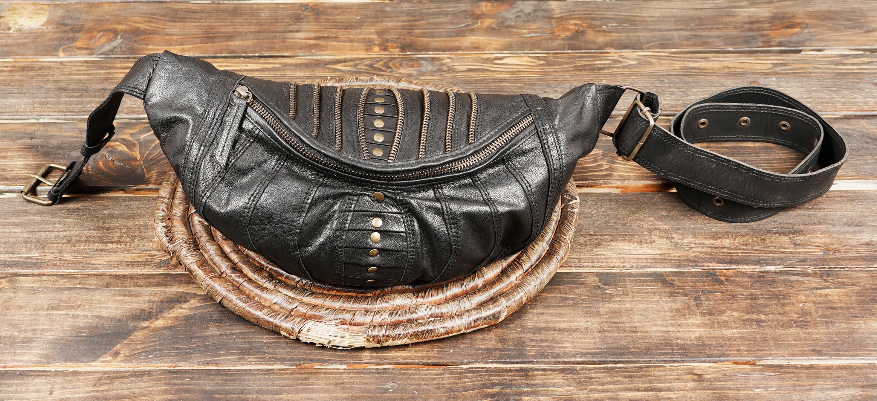 Gothic leather waist pack with metal rivets and adjustable strap for comfort.