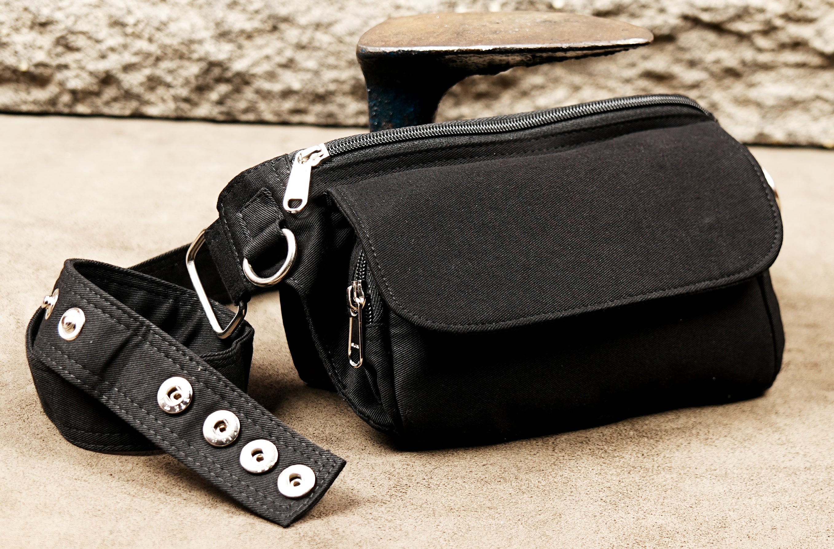 Edgy festival waist bag featuring nickel hardware and rugged cotton material.