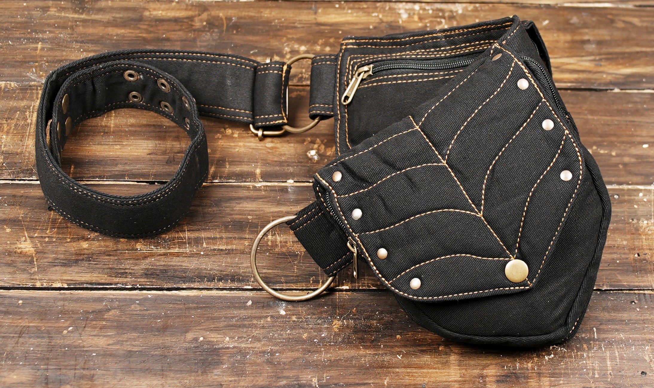 Two-pouch waist pack for essentials, crafted from black cotton canvas with distinctive gold stitching.