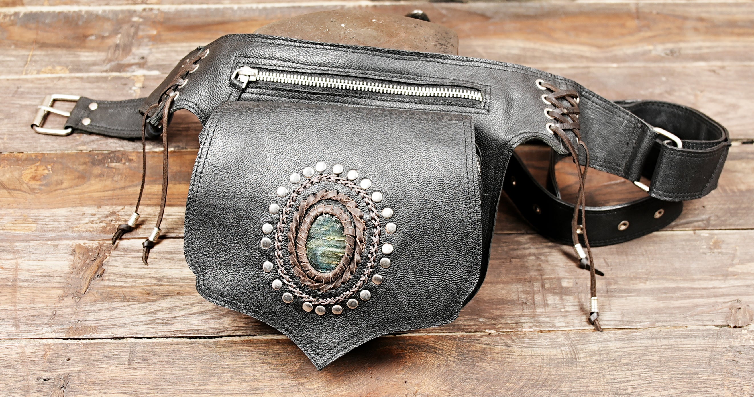 Close-up of handcrafted leather waist bag showing gemstone and silver stud detail