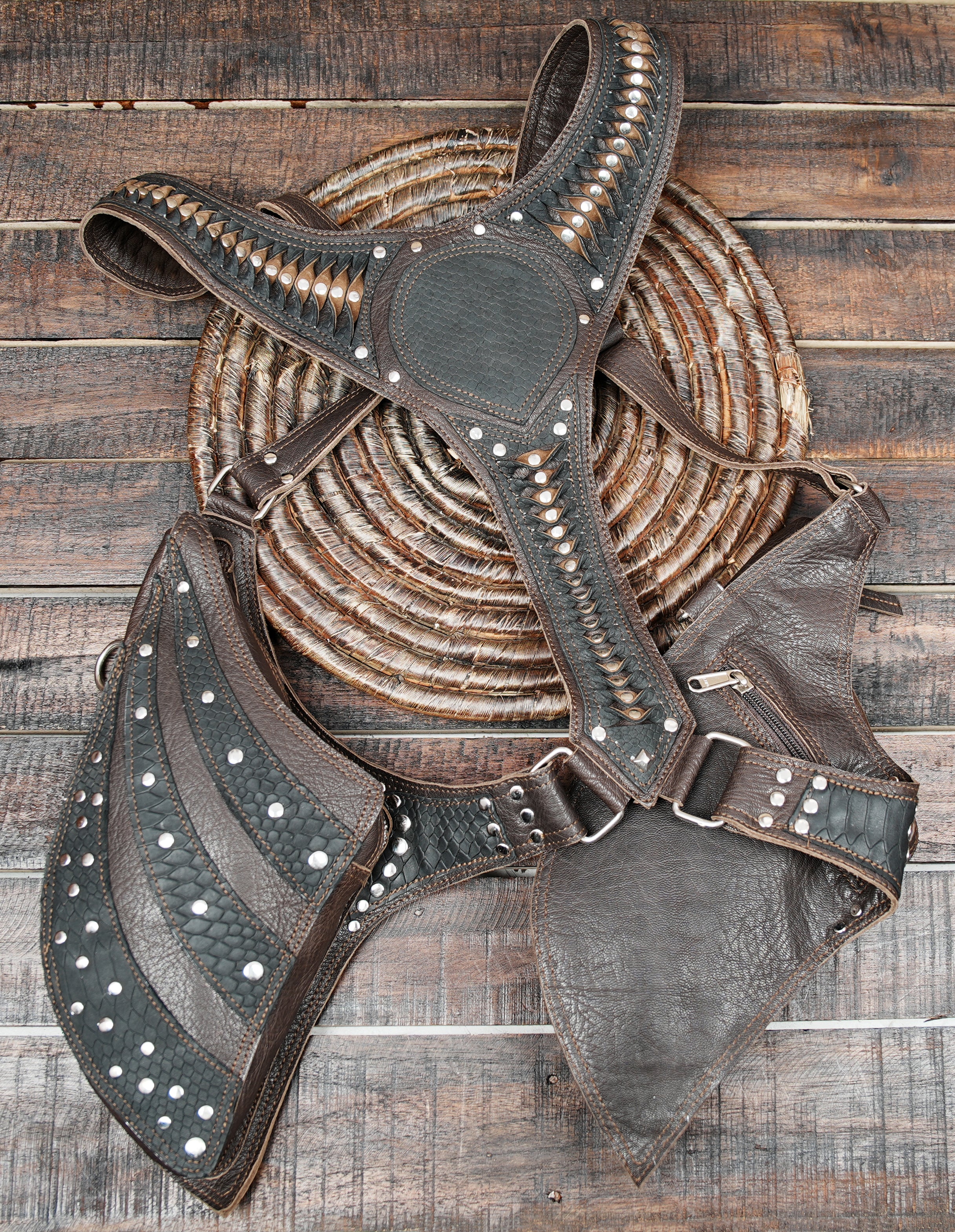 it features scaled panel patterns, silver studs, and artistic stitching that give it a tribal and gothic look.