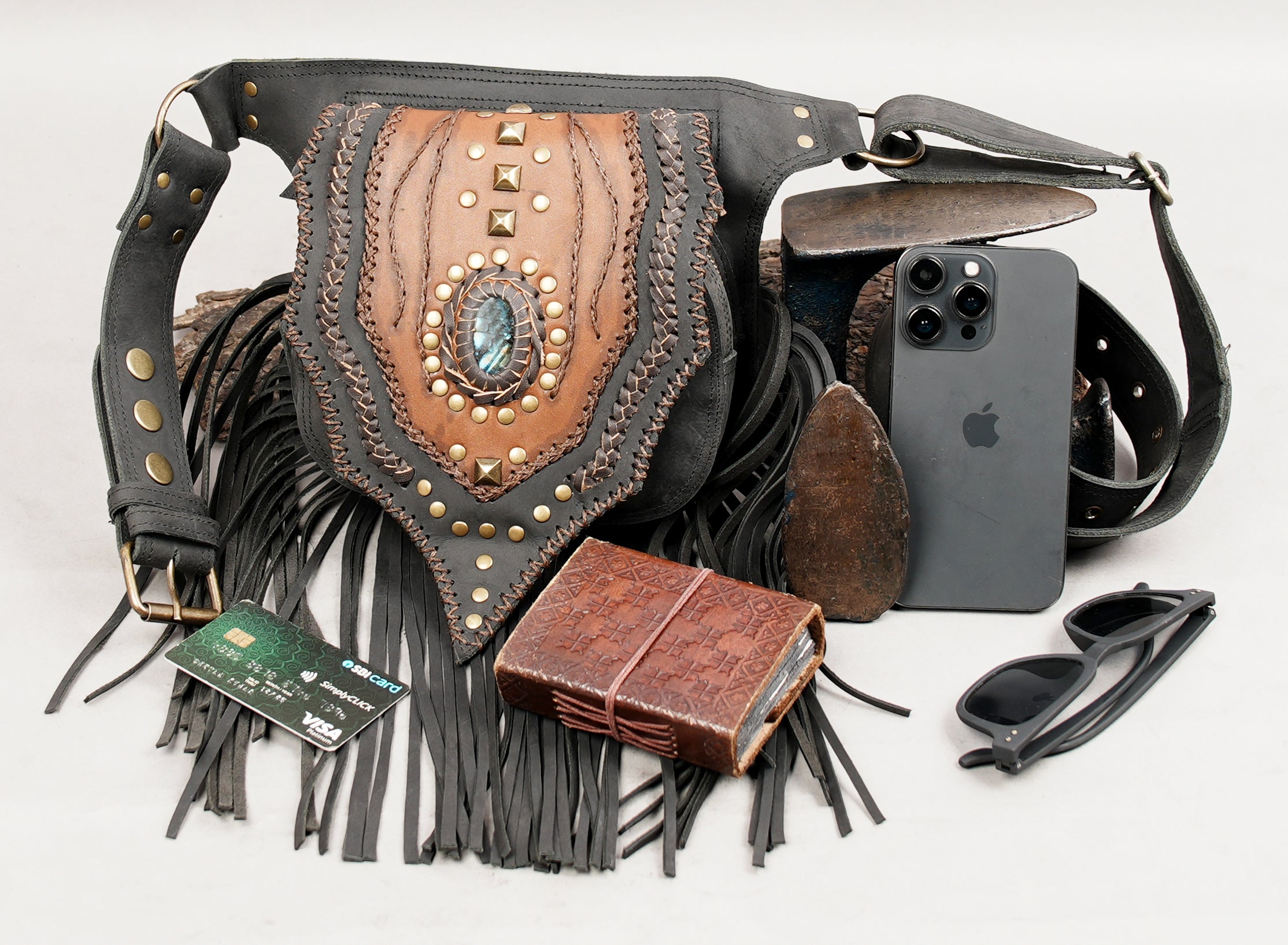 Leather festival hip pouch with gemstone centerpiece and fringe bottom.