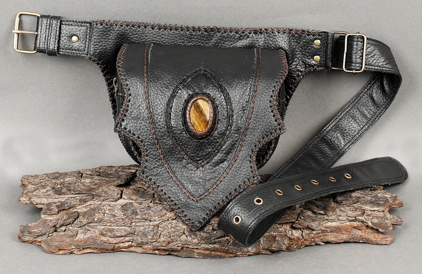Black leather hip pack with sculpted design and gemstone accent