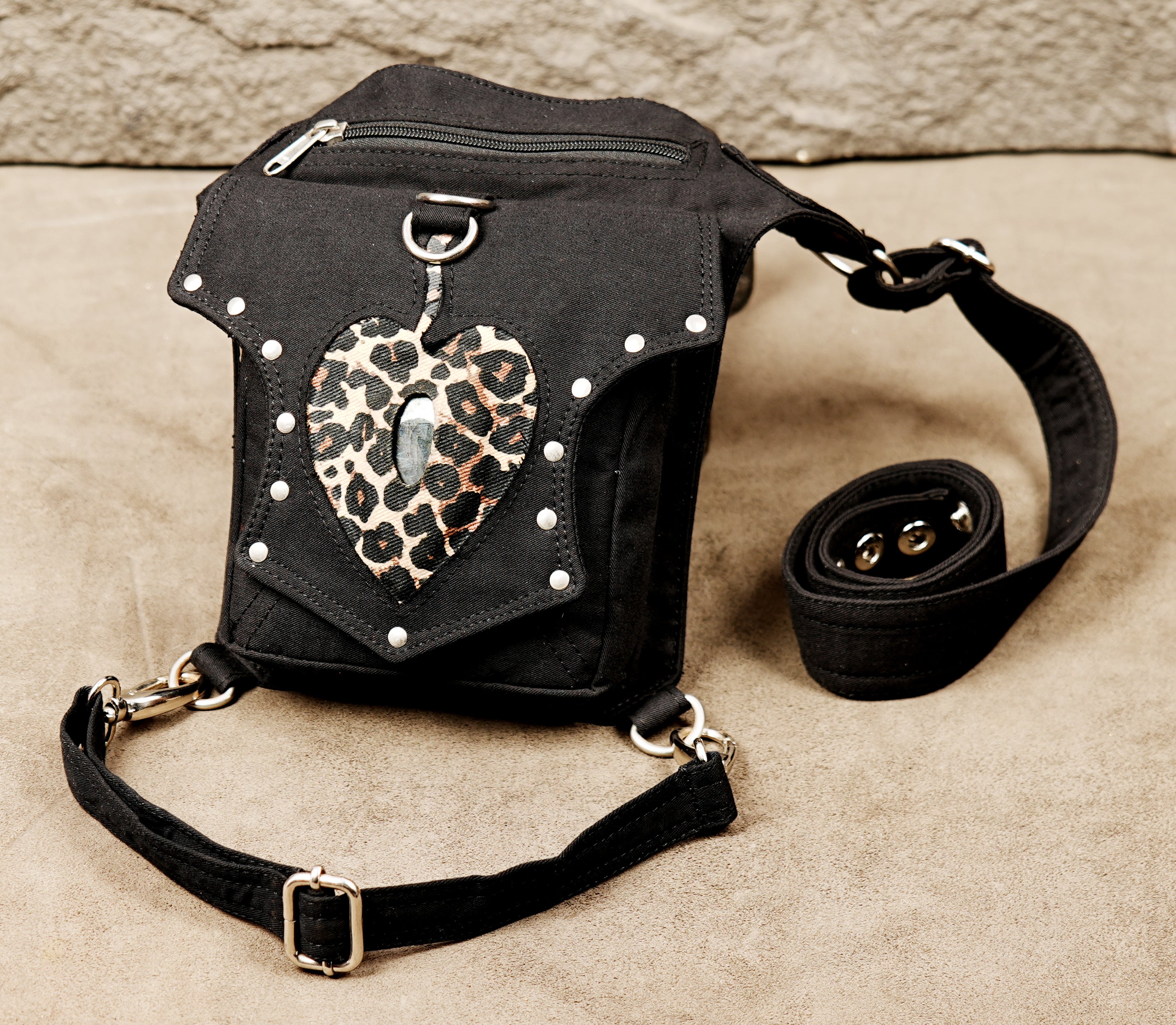 This fashion accessory combines utilitarian function with a bold, decorative leopard print heart.