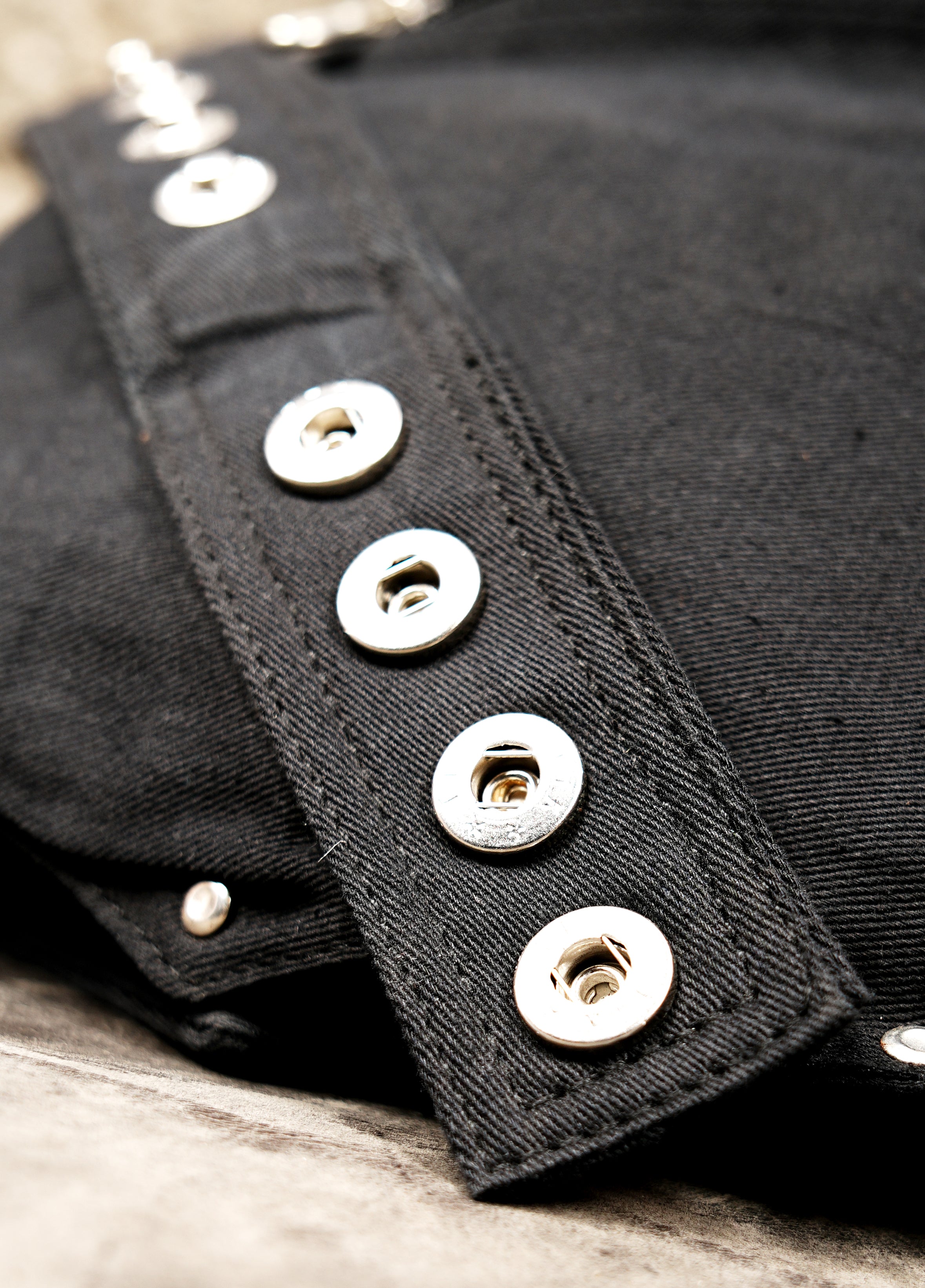 Studded black bumbag with corset-style lacing, a gothic festival essential in Europe.