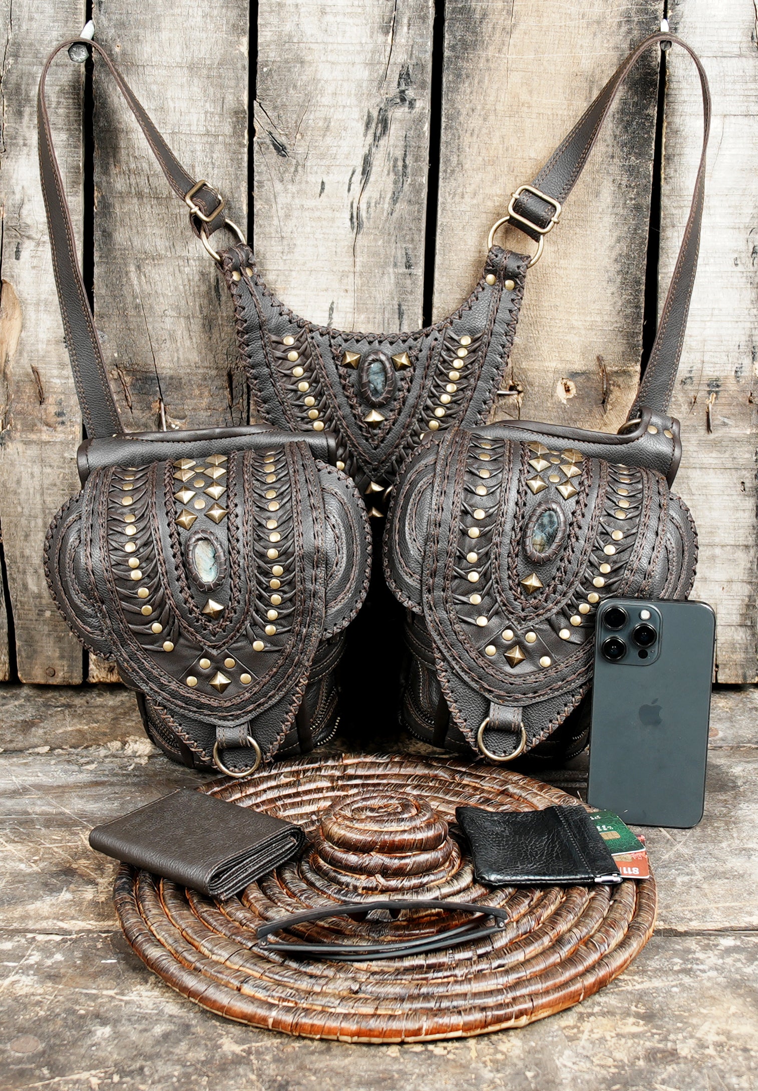 “Leather crossbody holster with ornate tribal designs and brass hardware”