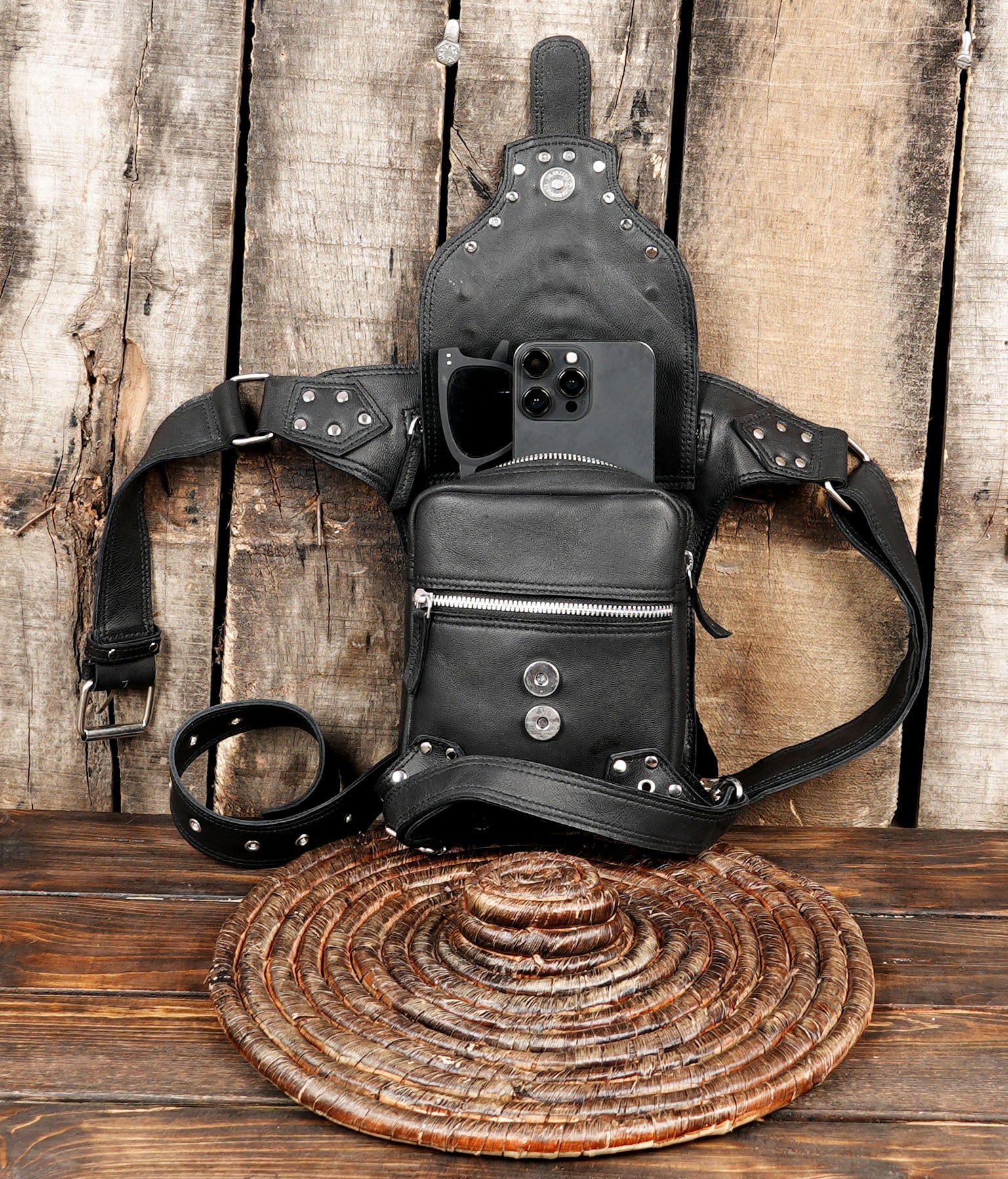 Black leather festival leg bag laid flat on wooden background