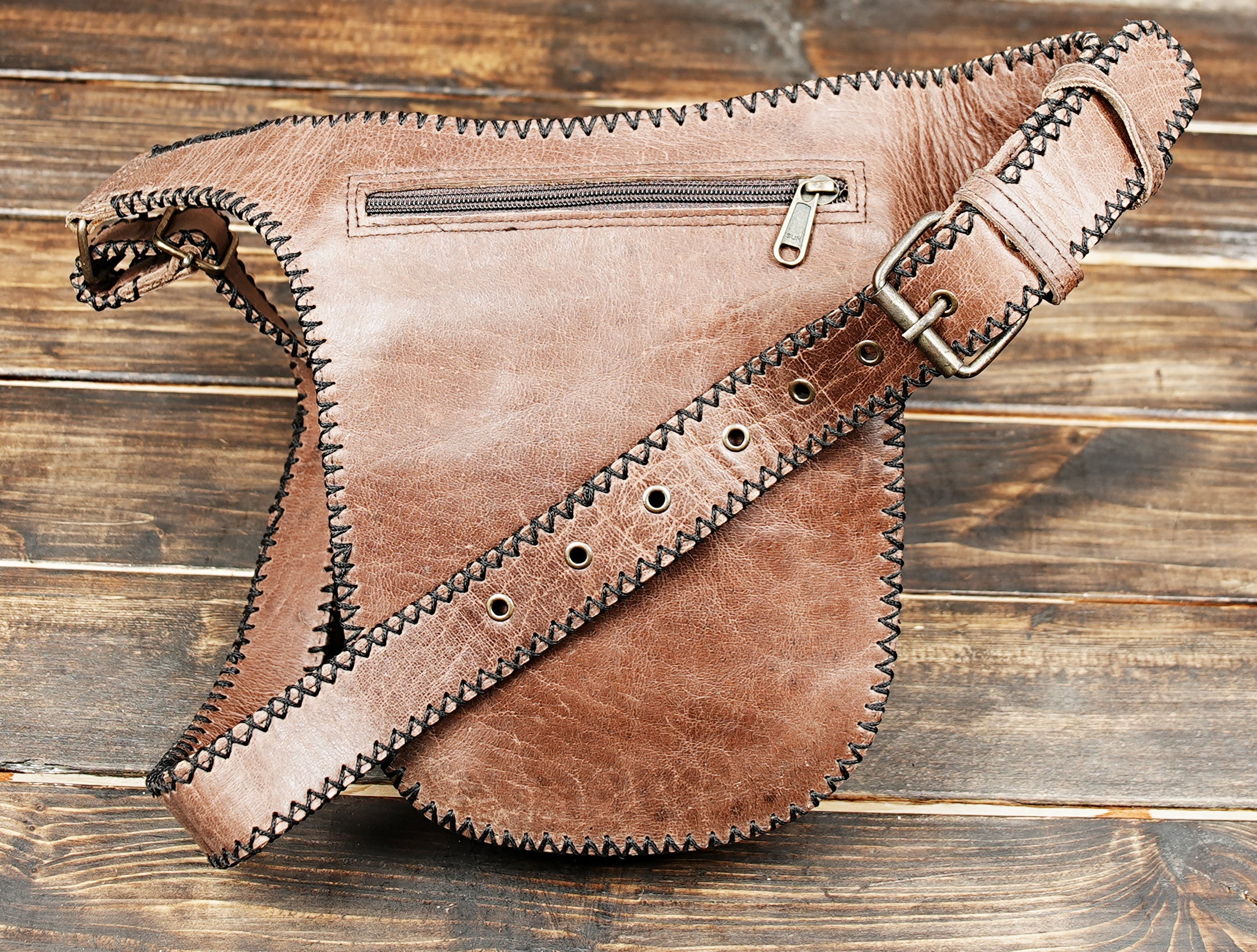 Brown and black stitched leather waist pack with secure zipper pocket