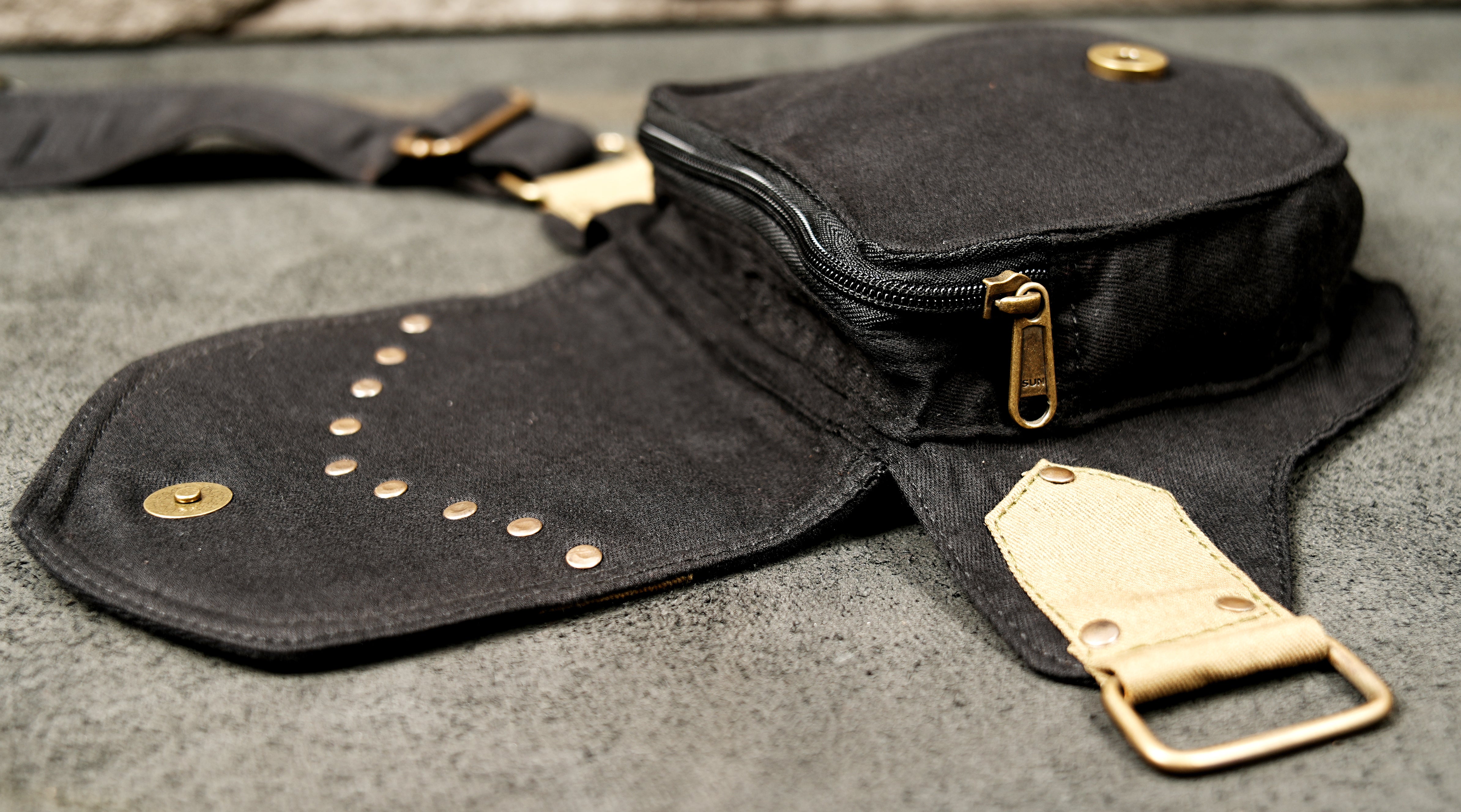 Shot of a sturdy, adjustable fabric waist strap and the bag attachment points.