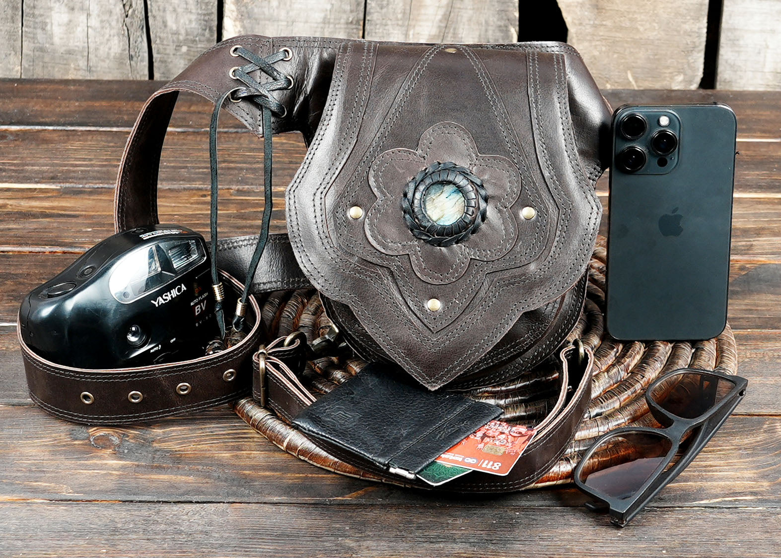 Bohemian-style leather belt bag with decorative flower pattern and gemstone detail.