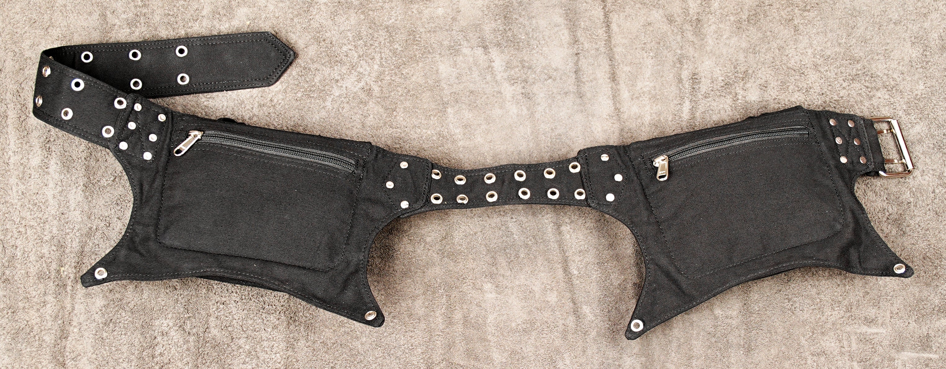 Rave-ready utility belt with multiple pockets and decorative eyelet strap.