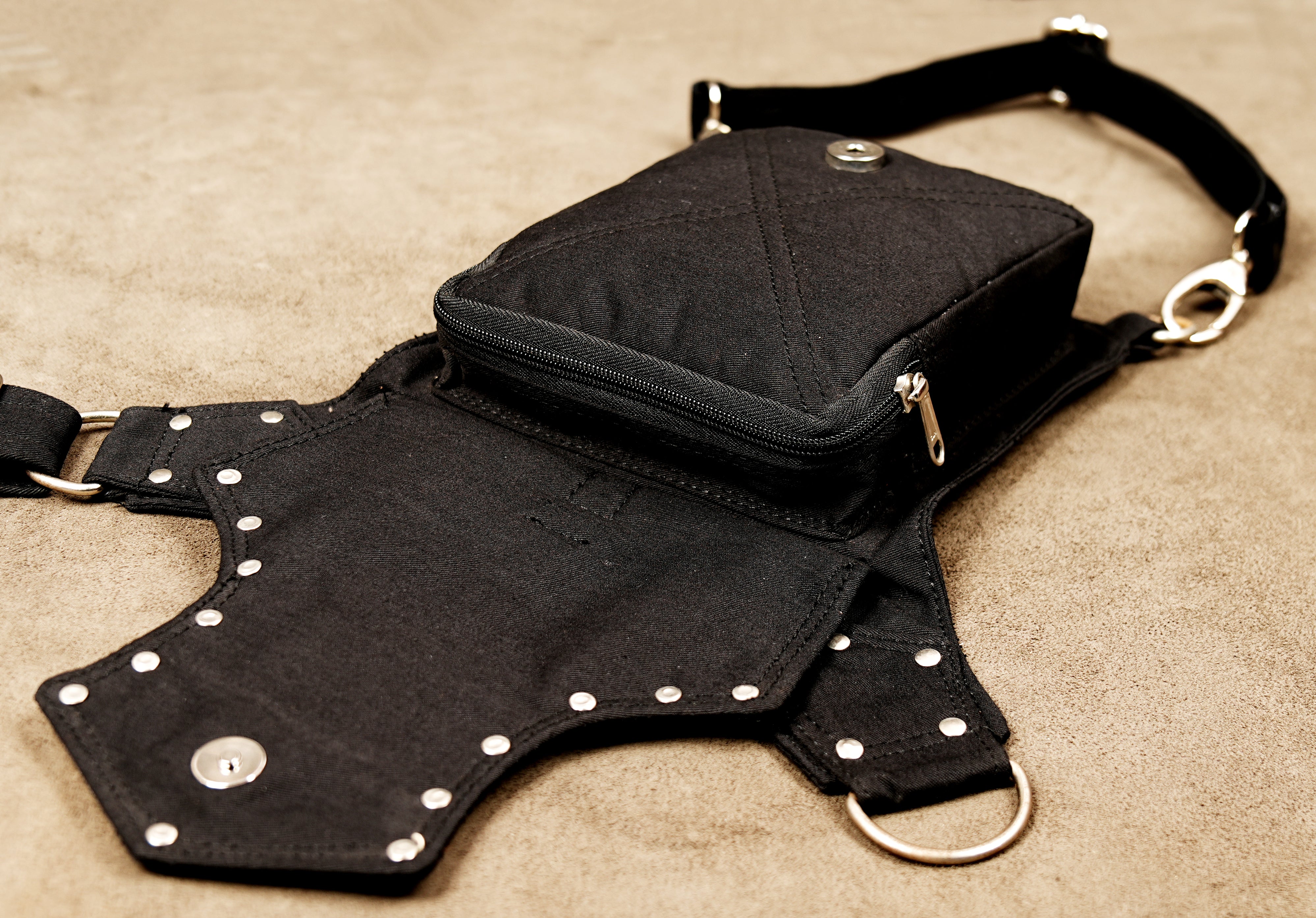View of the intricate stud and rivet placement on the black cotton bag panels.