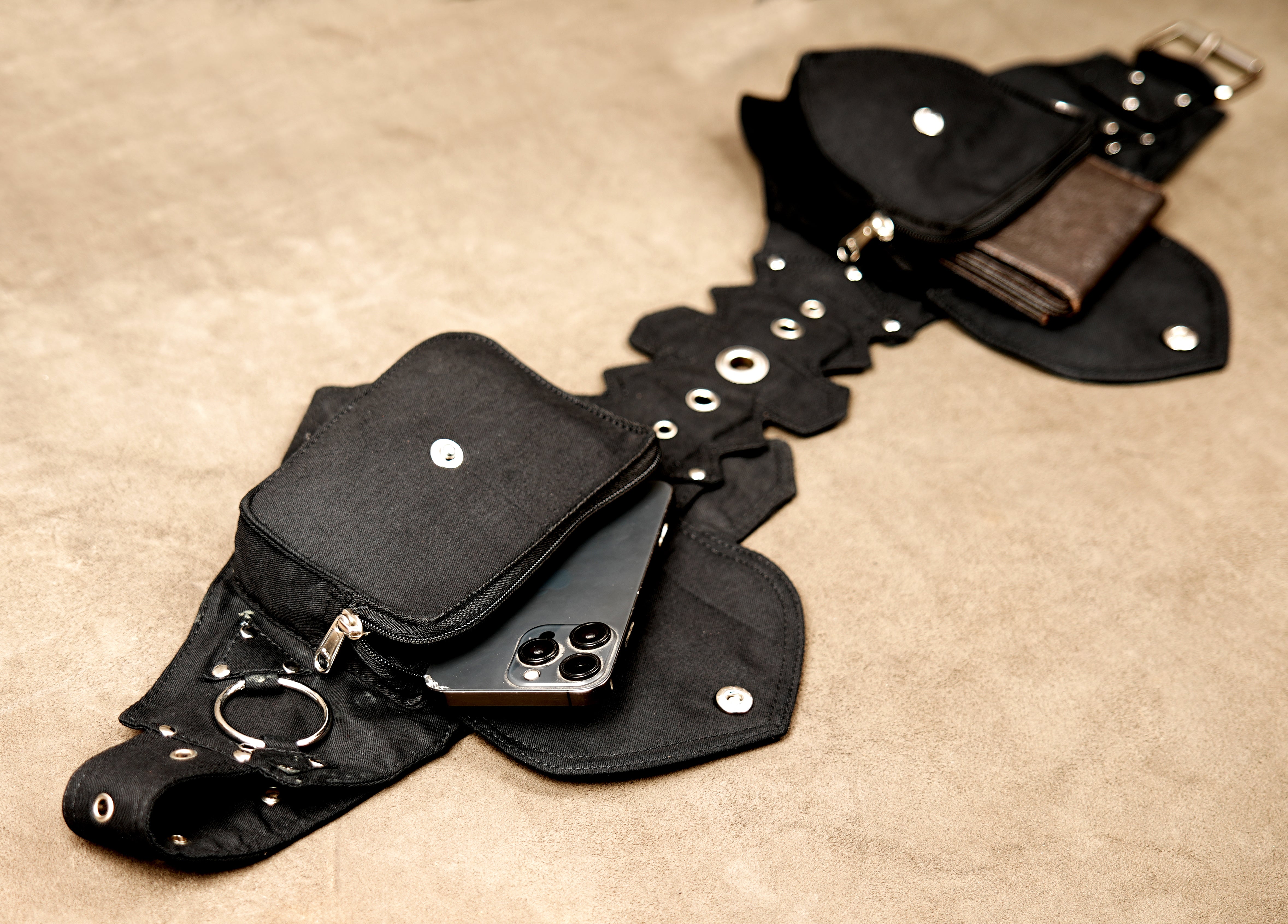Boho-chic festival belt bag with pockets and metallic stud accents.