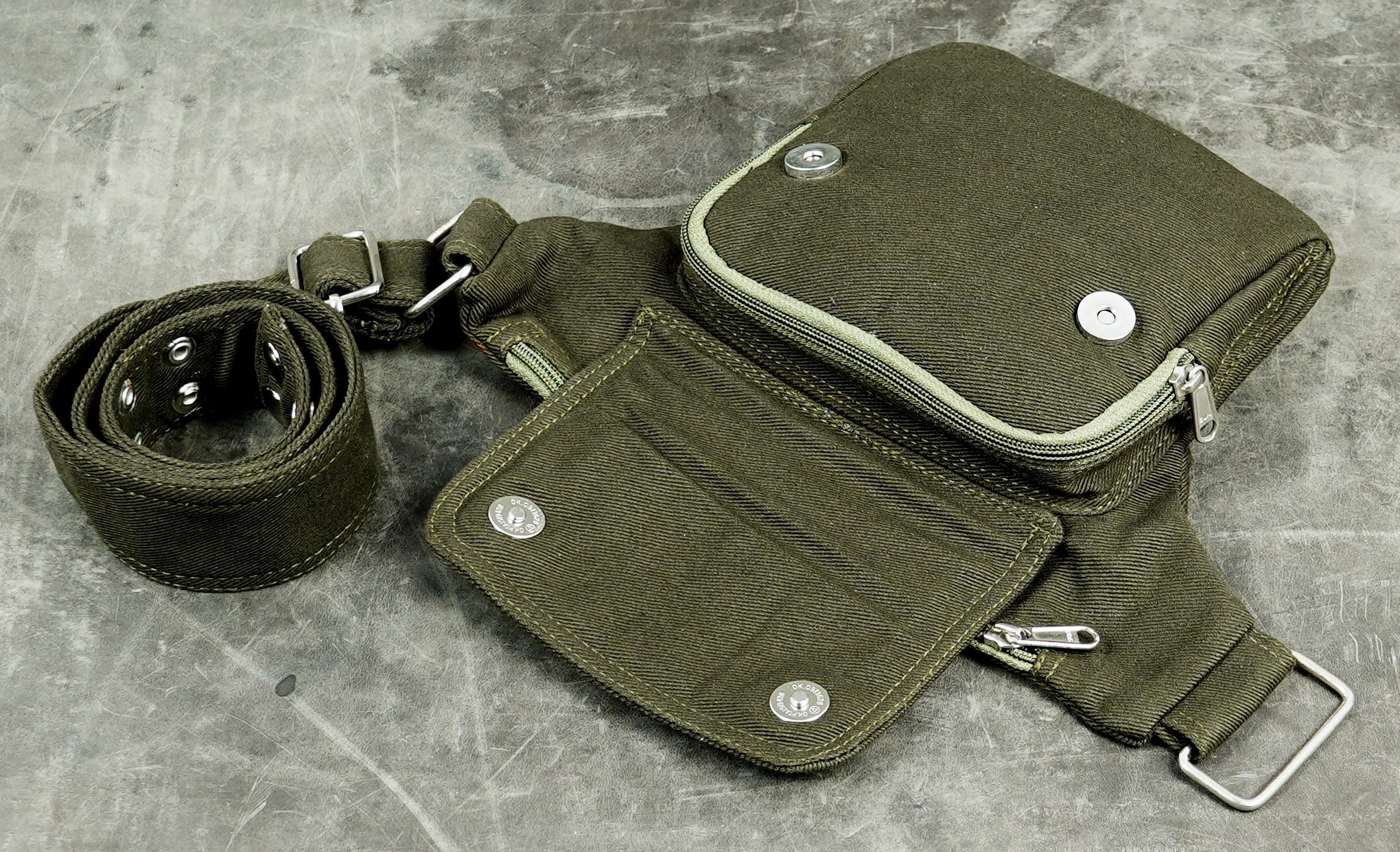 Unisex olive canvas bum bag with zippered top pocket and flap front