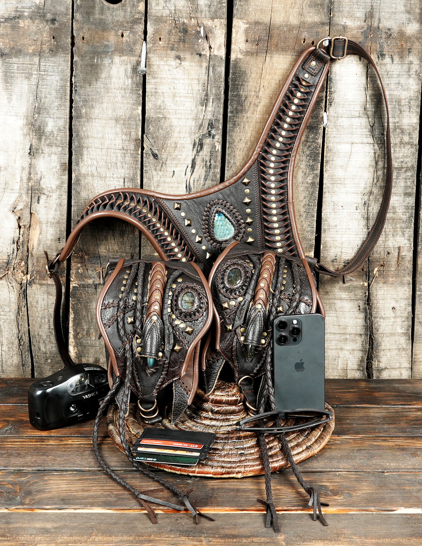 “Dark brown leather crossbody holster with tribal motifs and long leather tassels”