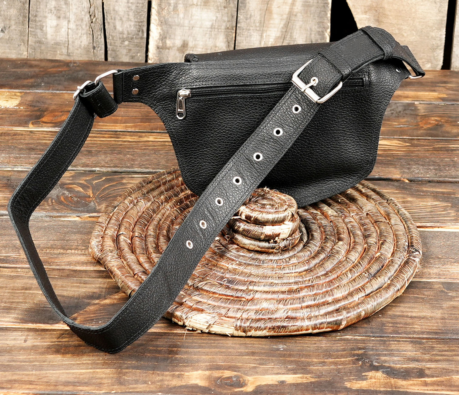Close-up of black leather waist pouch showing gemstone inlay and handcrafted texture