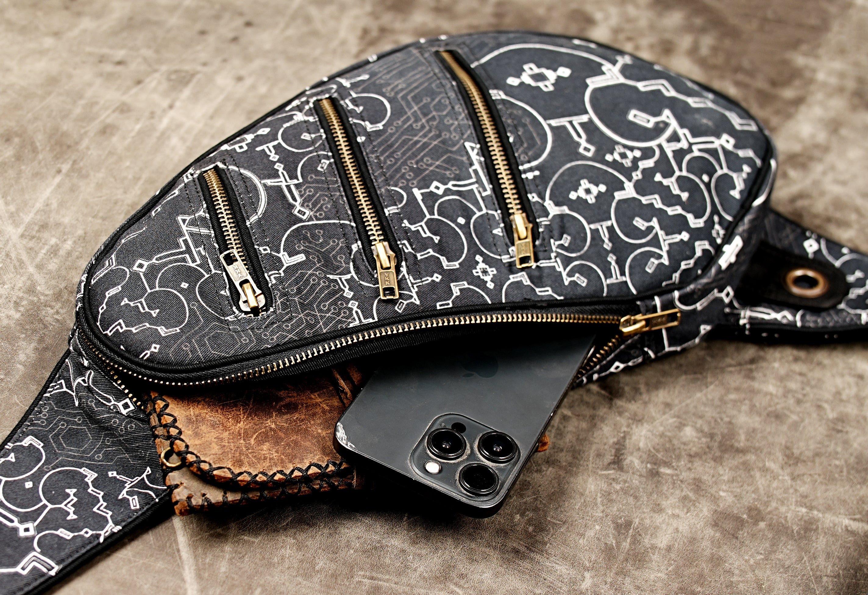 Black sling bag laid flat showing full strap and pocket layout