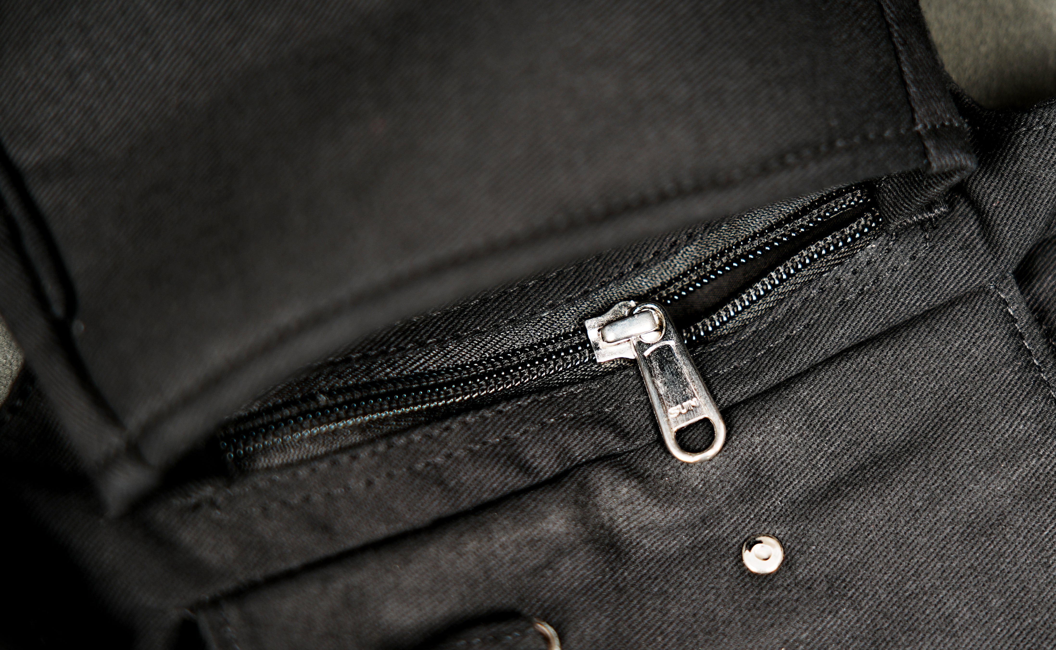 Black cotton festival waist pack with multiple compartments zip closure and silver-tone metal details.
