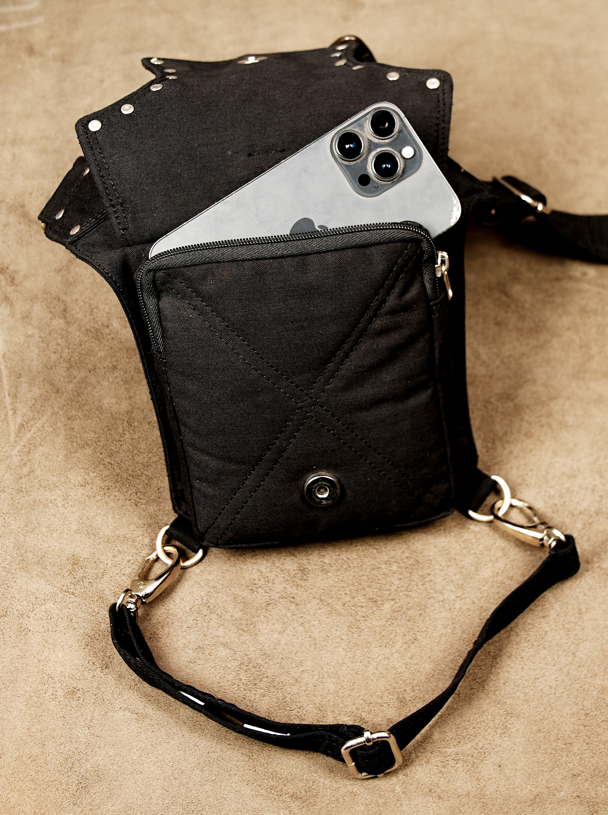 This belt bag is made of black cotton fabric, featuring contrasting metal hardware and animal print.
