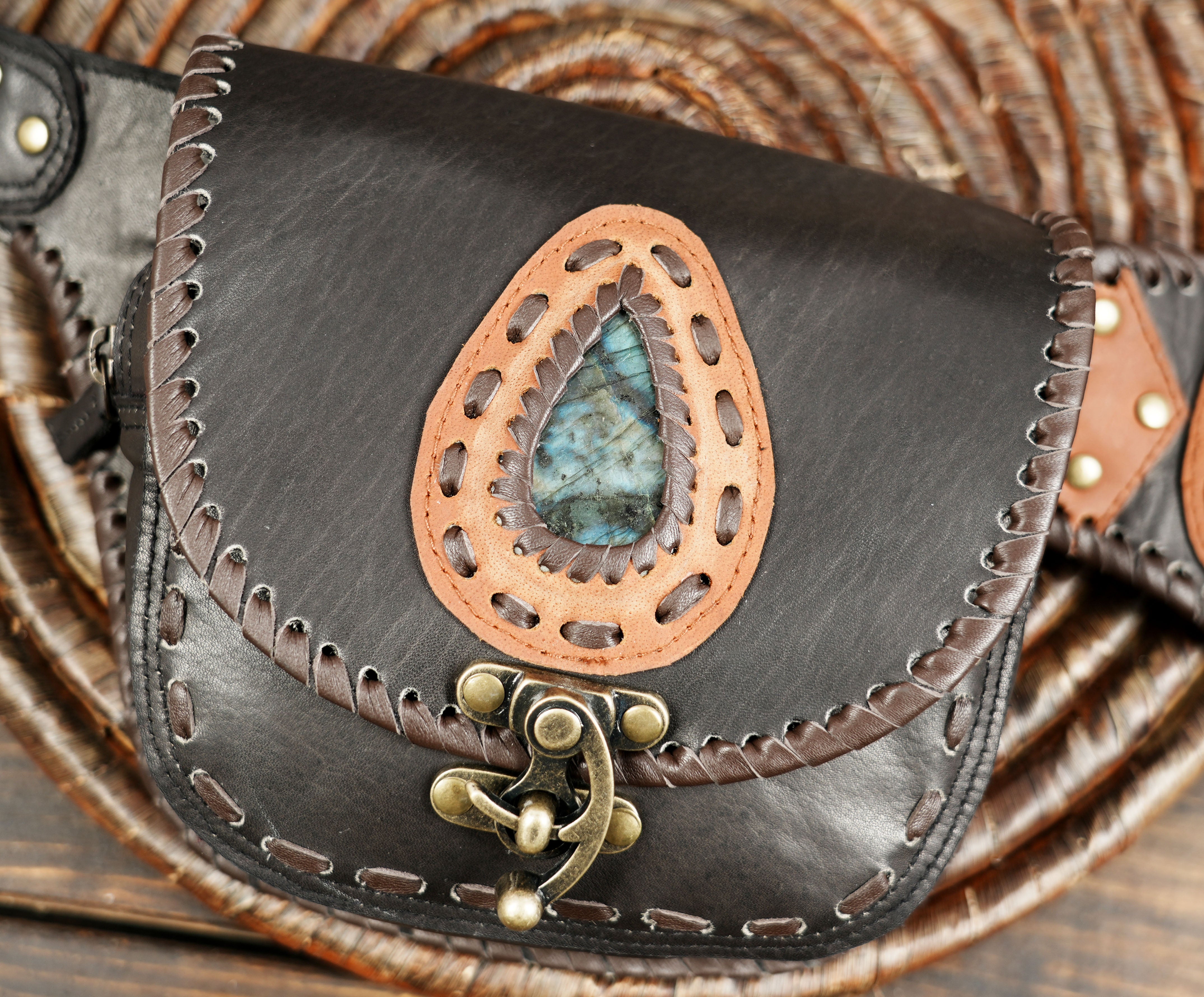 Vintage-style brown leather belt bag featuring twin pouches and brass clasps.