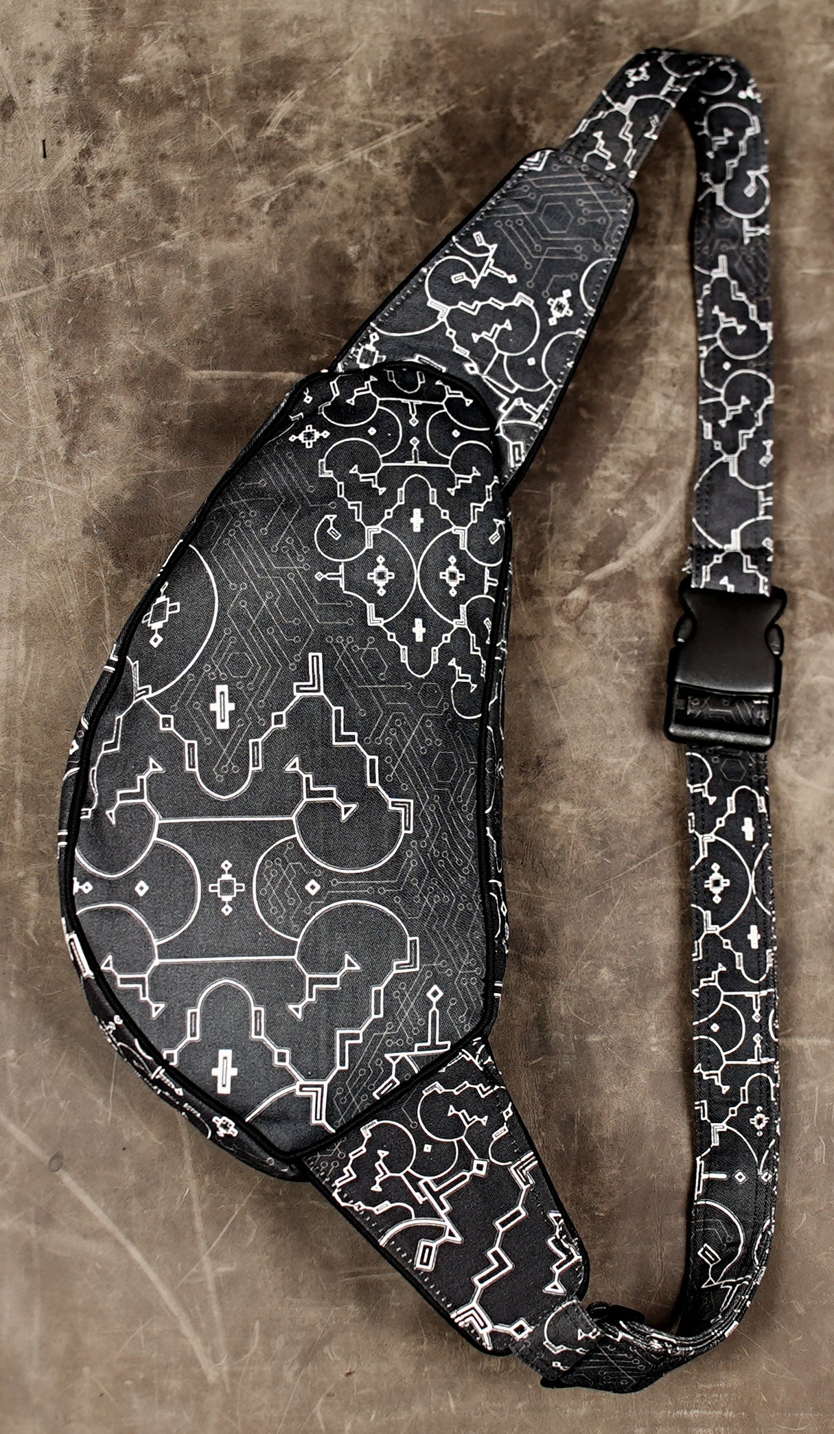 Black shoulder bag with brass eyelet and adjustable buckle strap