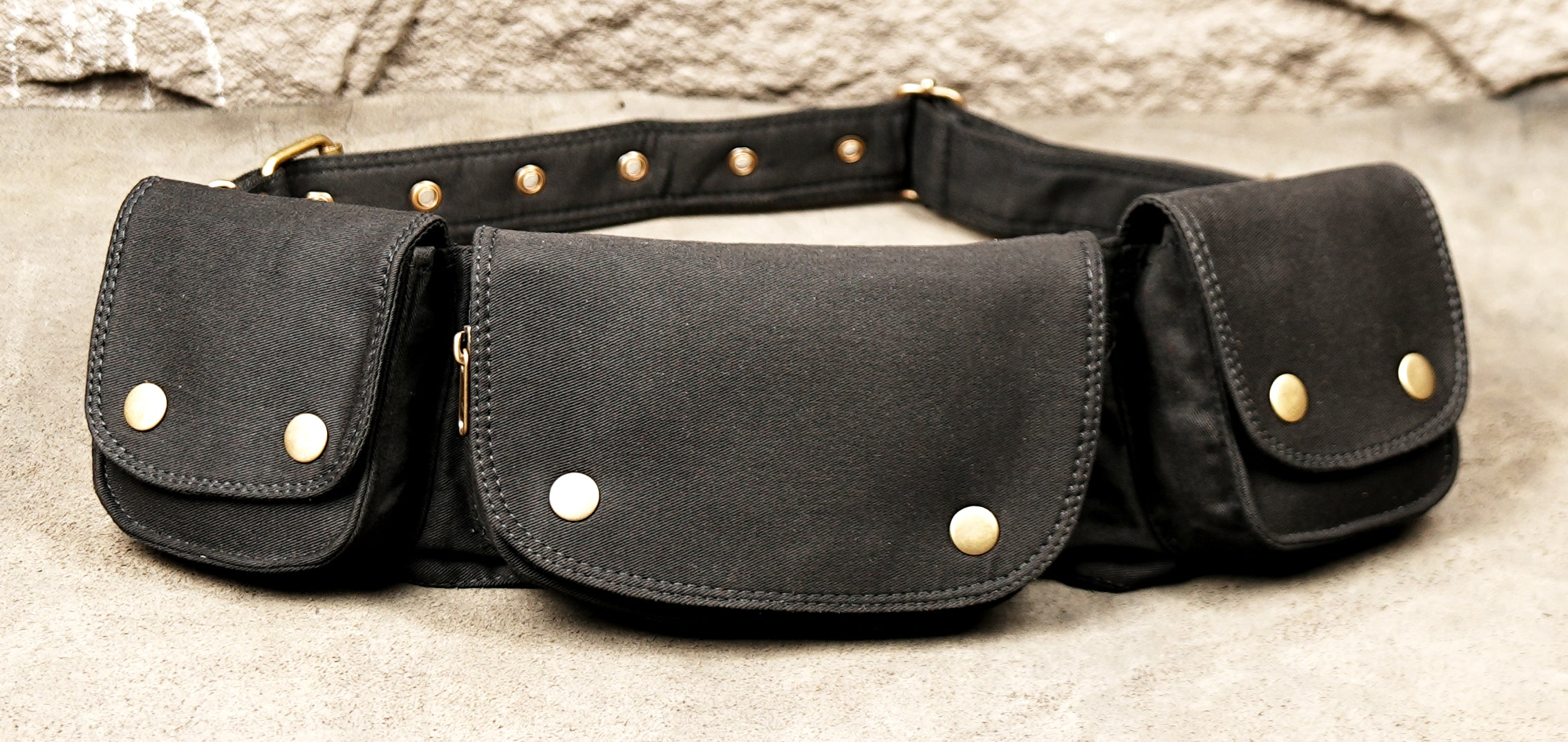 Black canvas utility belt with four pockets and adjustable strap