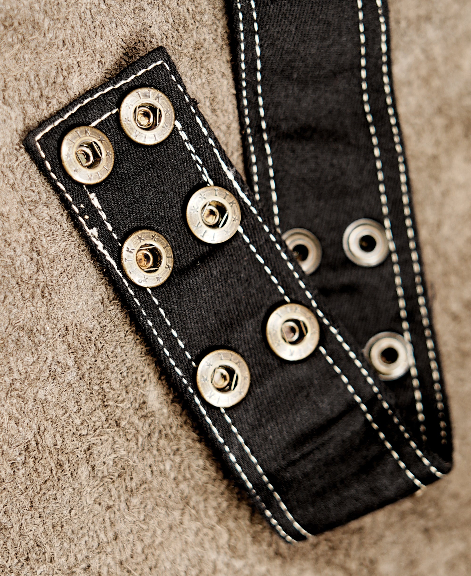 Adjustable black cotton fanny pack with two decorative pockets