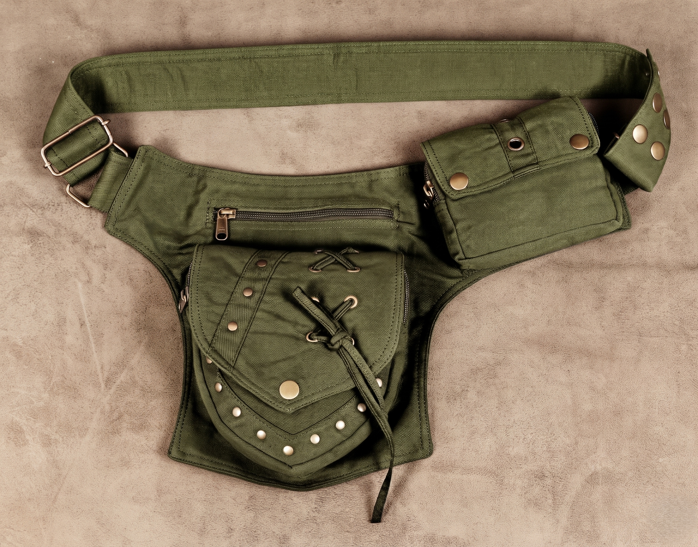 An olive green canvas fanny pack with multiple utility pockets, brass-tone rivets, and a matching adjustable shoulder strap.