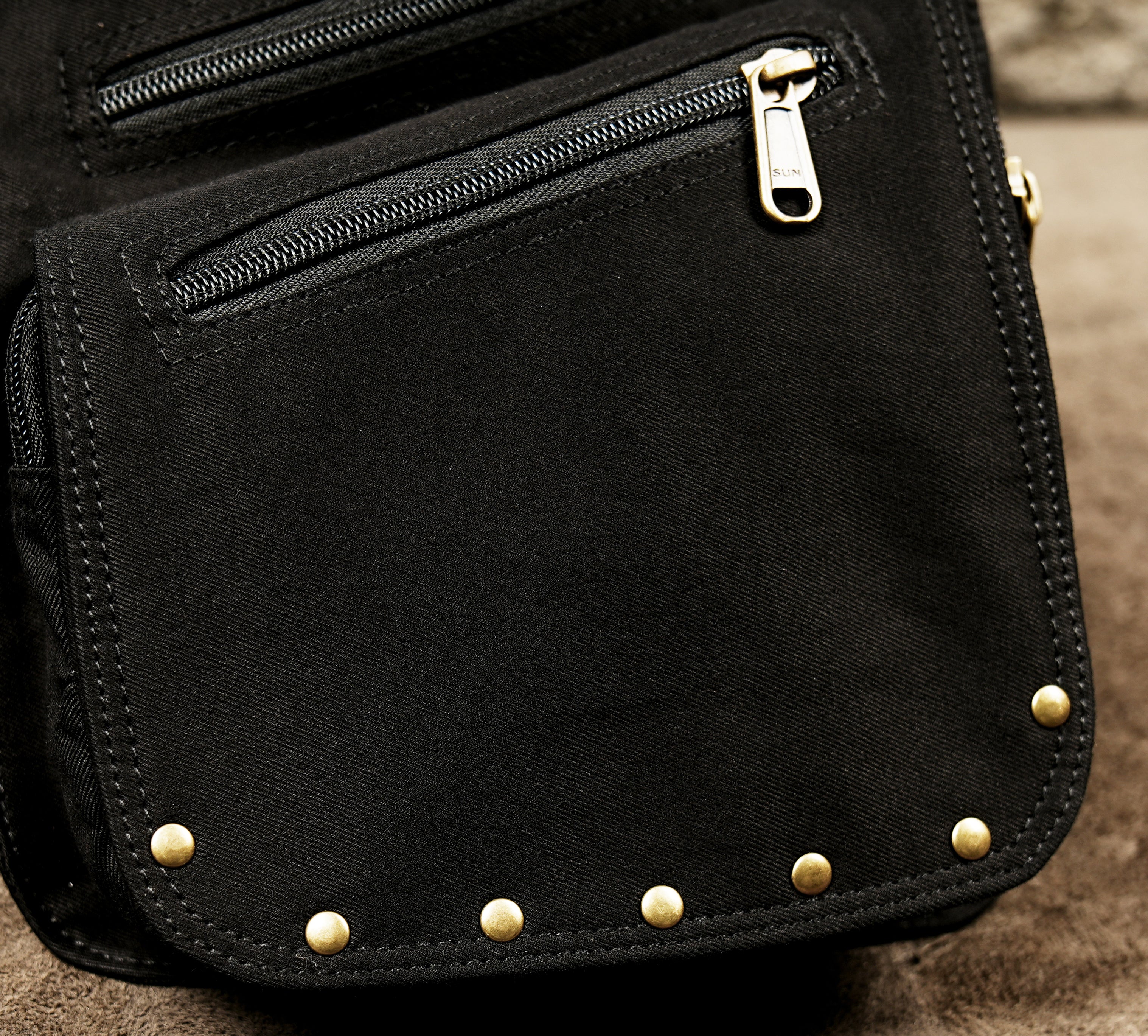 Black cotton harness bag with two pouches and brass hardware