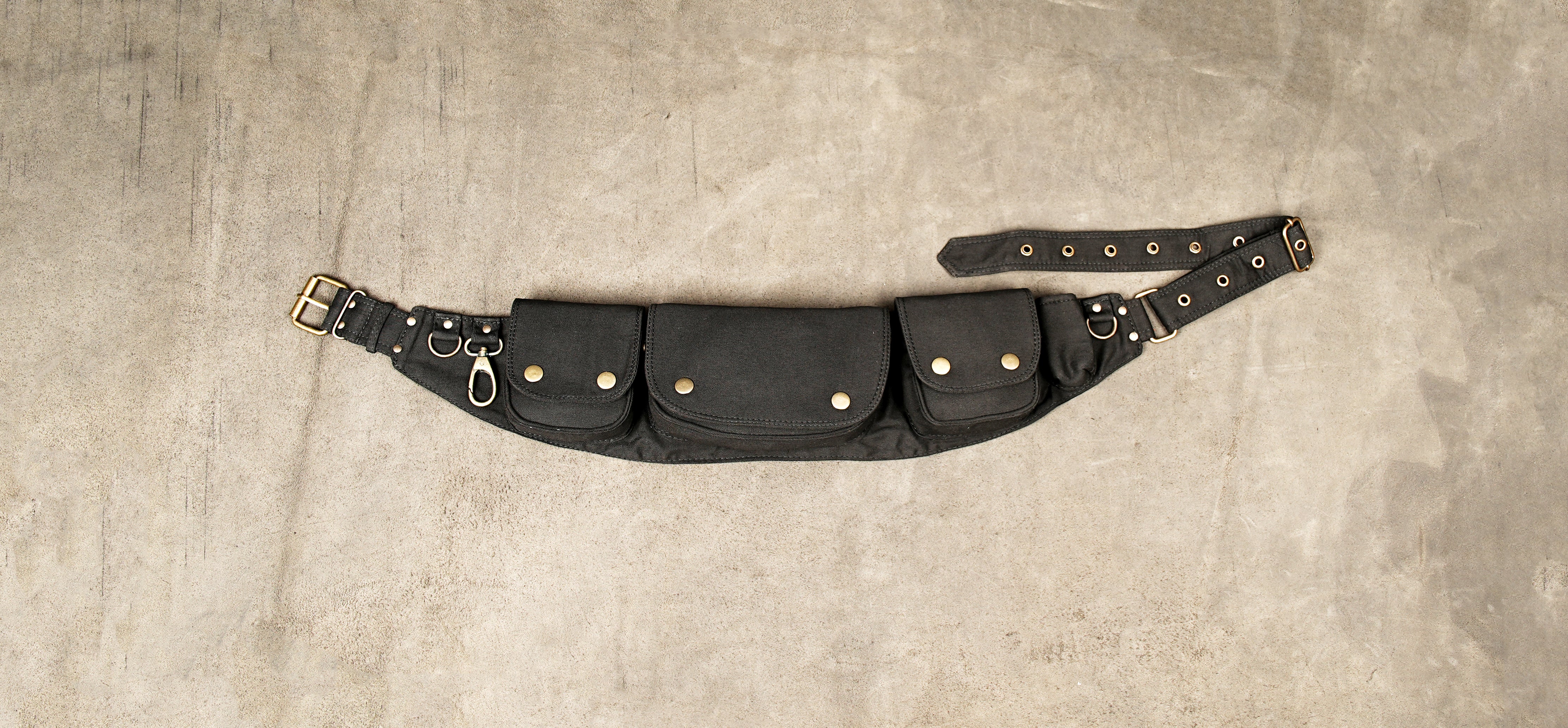 Black cotton waist belt with multiple snap pockets and brass buckle