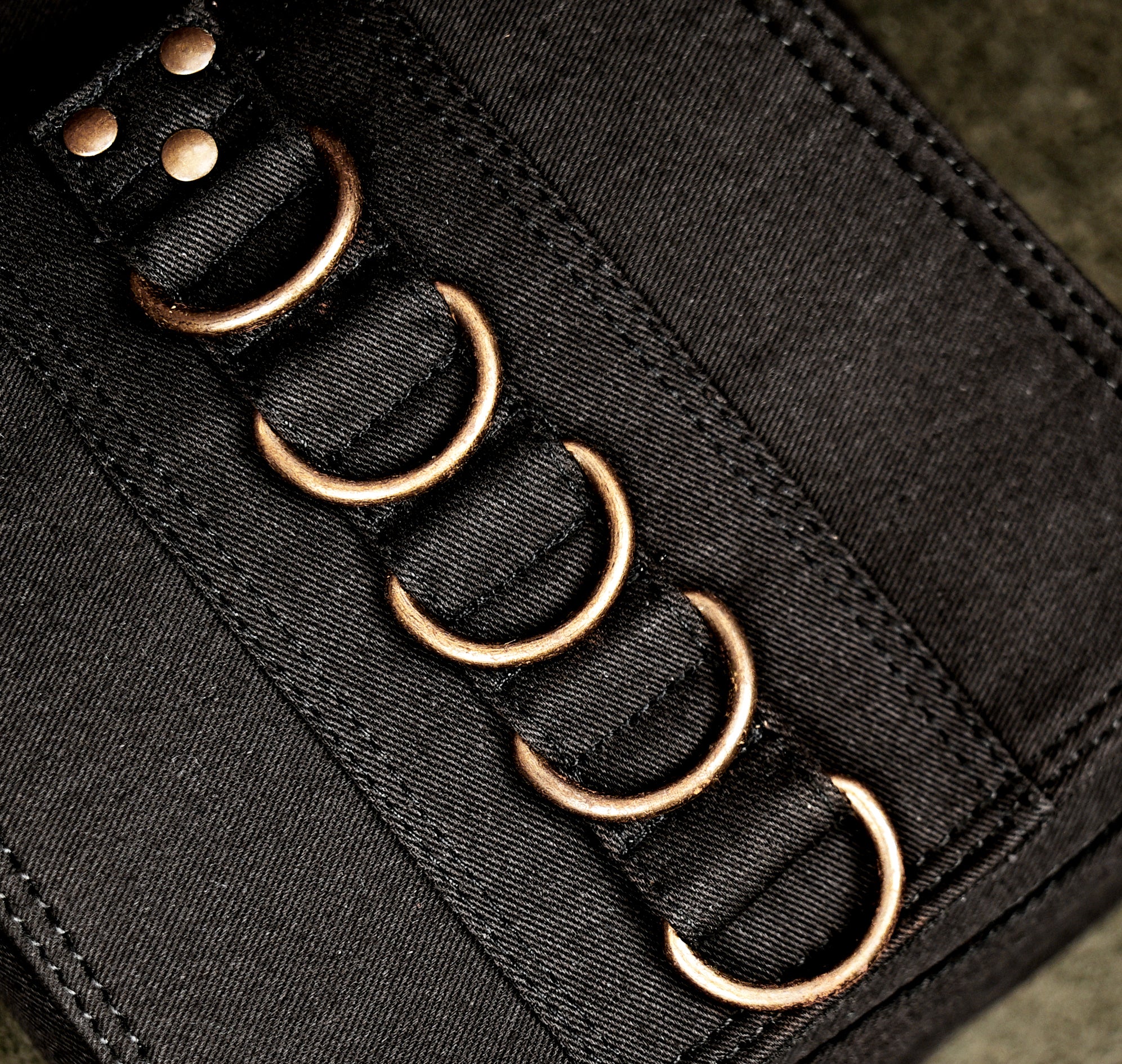 Black cotton belt bag laid flat showing waist and leg straps