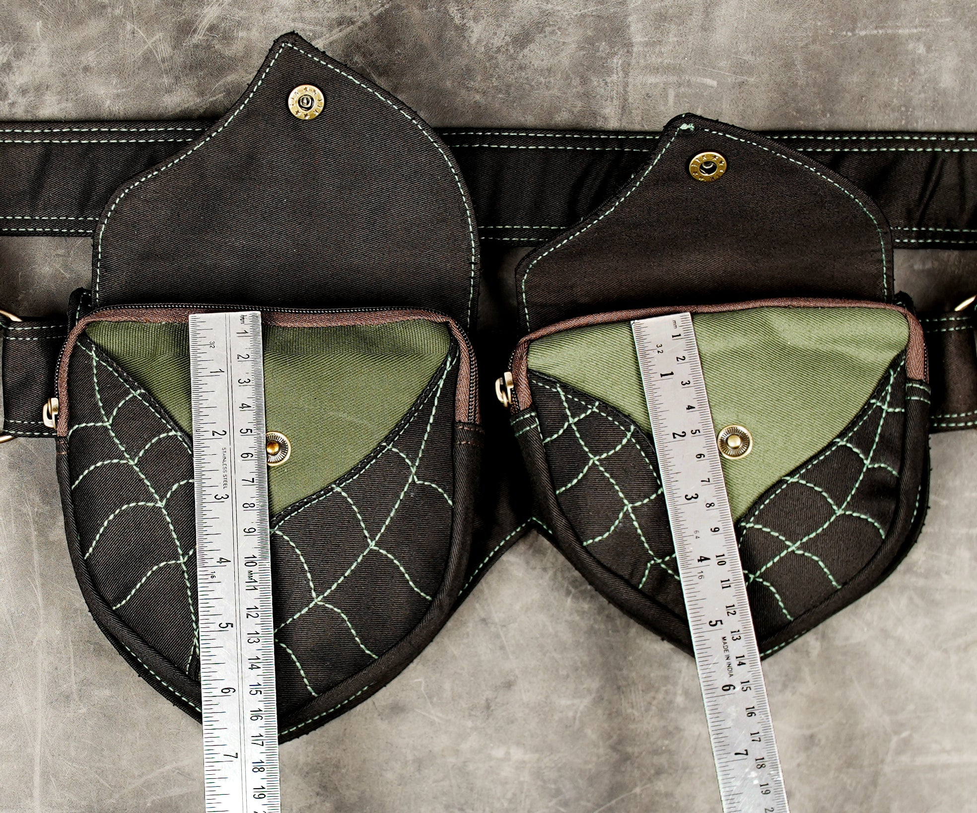 Unisex black cotton hip bag with two zippered pockets and green embroidered stitching