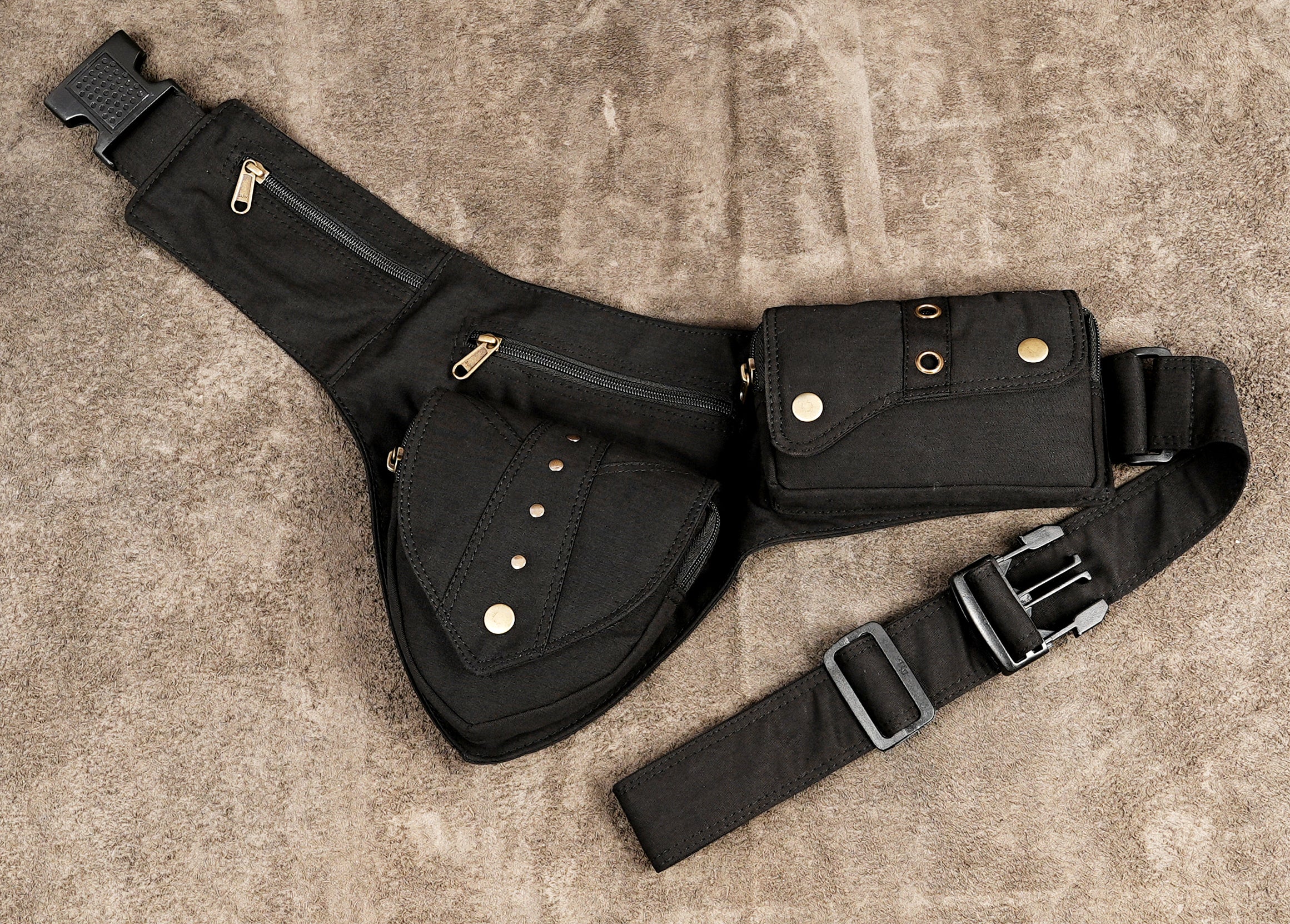 Black canvas cotton waist belt bag laid flat on textured background