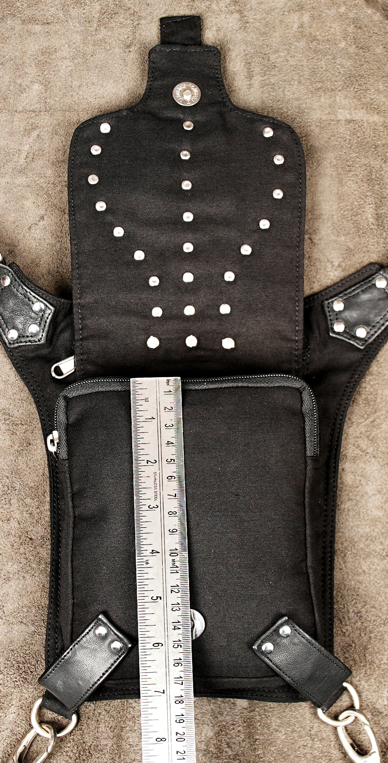 Dark wear clothing accessory: black multi-pocket leg pouch with distressed metal hardware.