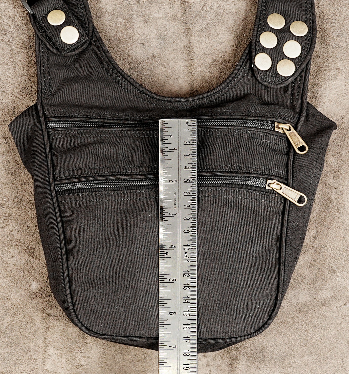 A black canvas shoulder bag with gold-tone hardware