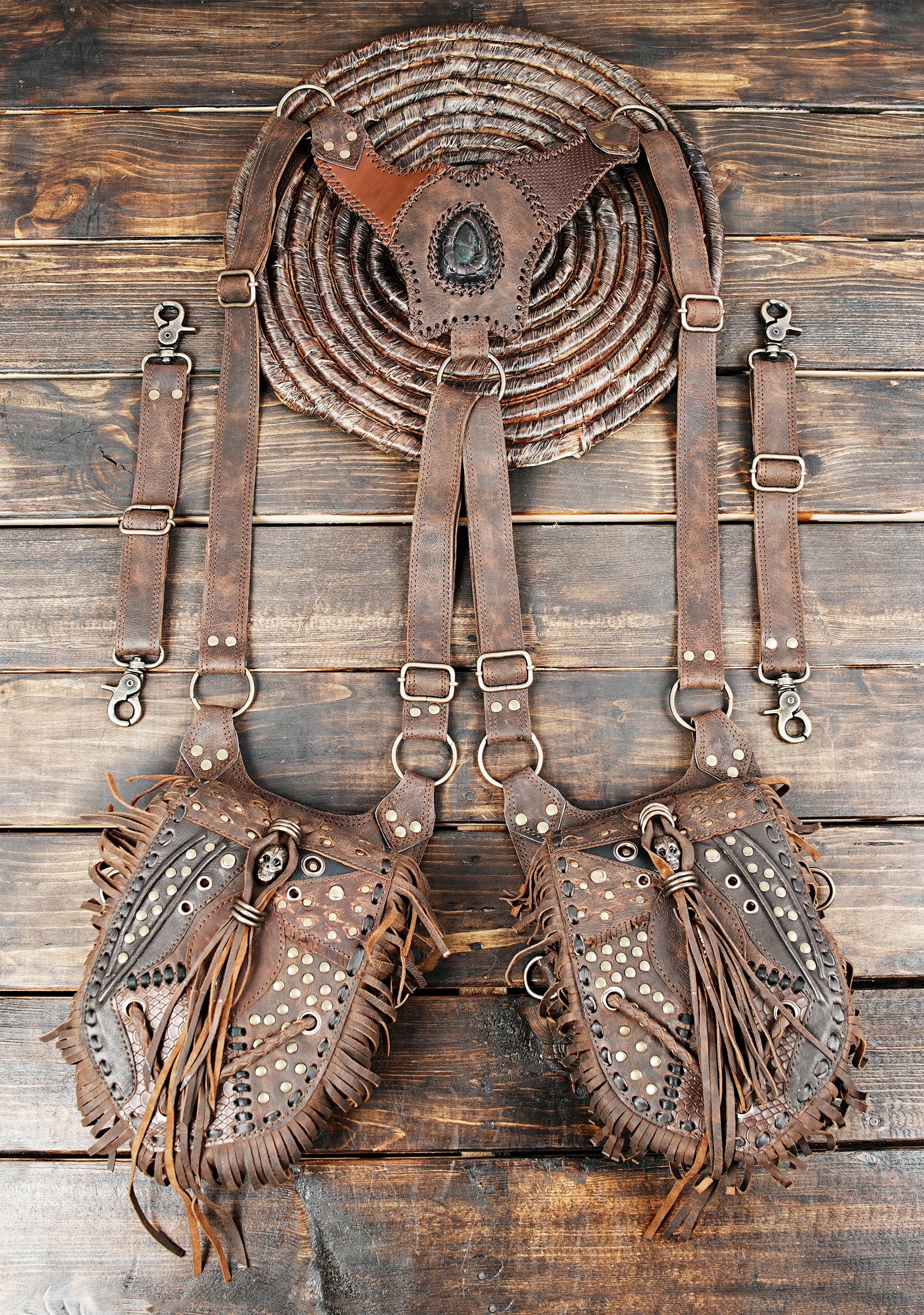 Handcrafted brown leather holster bag with fringe details and gemstone centerpiece.