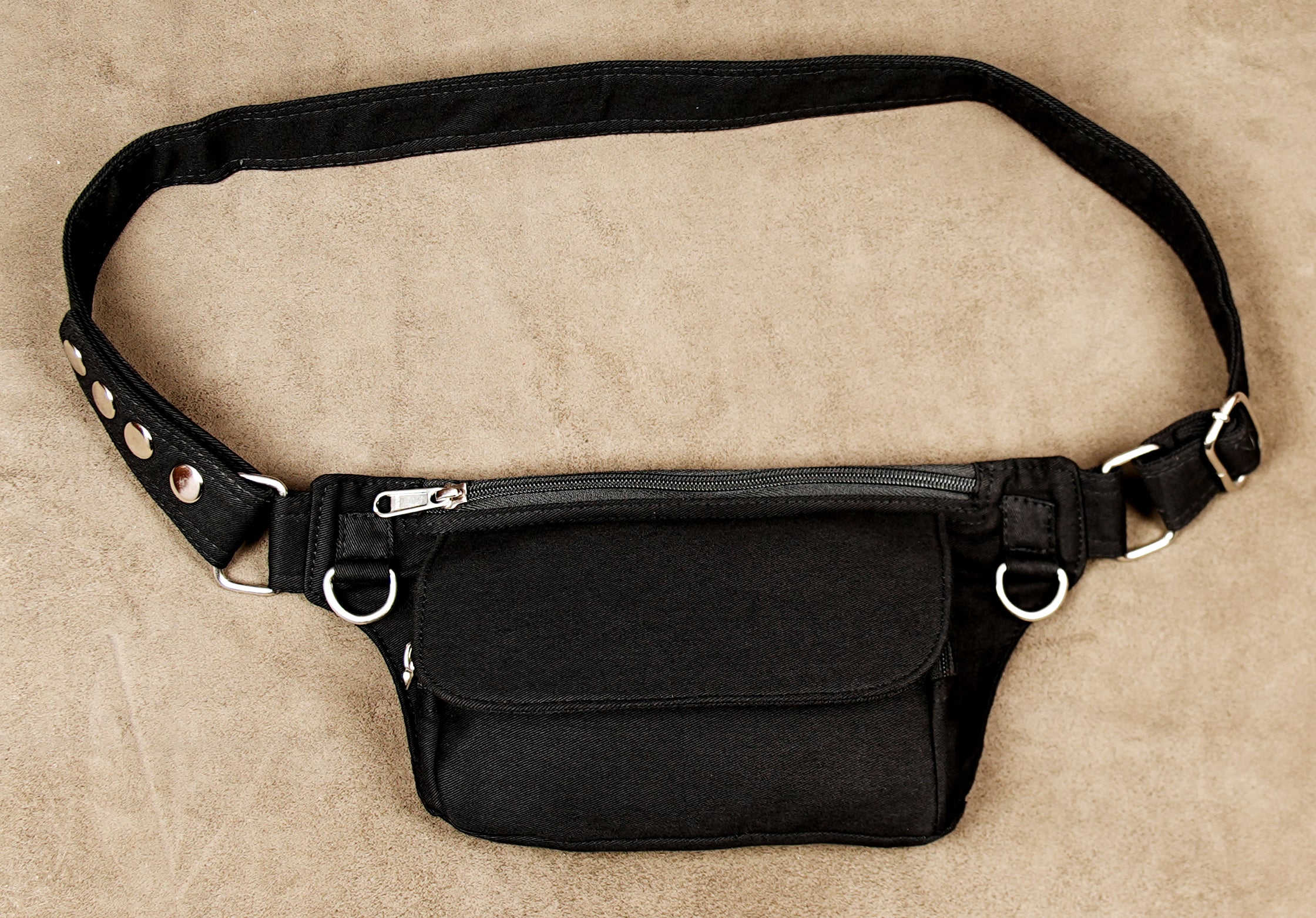 Casual street style waist bag in black with metallic buckle and eyelet details.