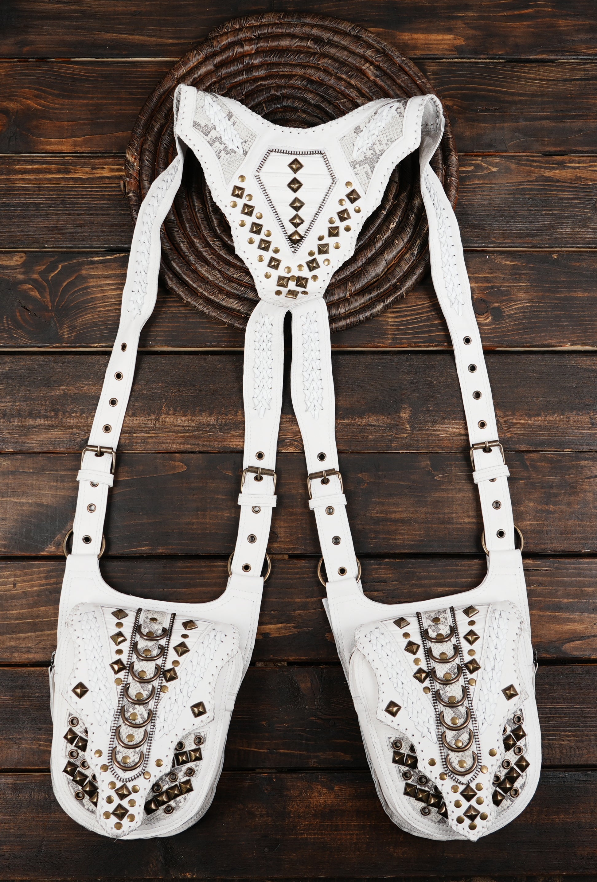 “Medieval-style leather harness holster with ornate patterns and rivets”